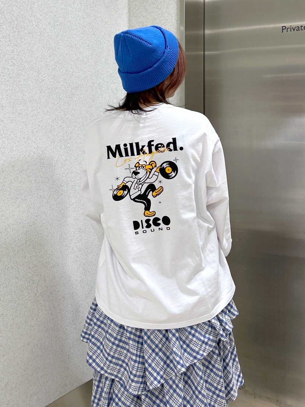 ホワイト系のTシャツ/カットソー、ブルー系のスカート、ブラック系のショルダーバッグを着用したレディースの冬コーディネートの4枚目の写真