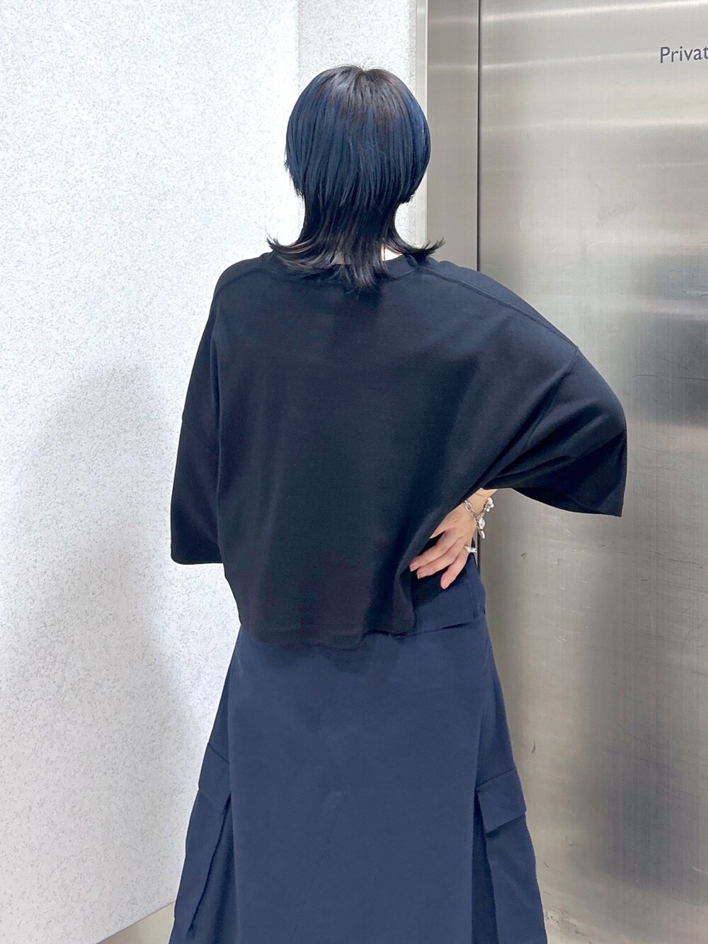 ブルー系のスカート、ブラック系のTシャツ/カットソー、レッド系のトートバッグを着用したレディースの夏コーディネートの8枚目の写真