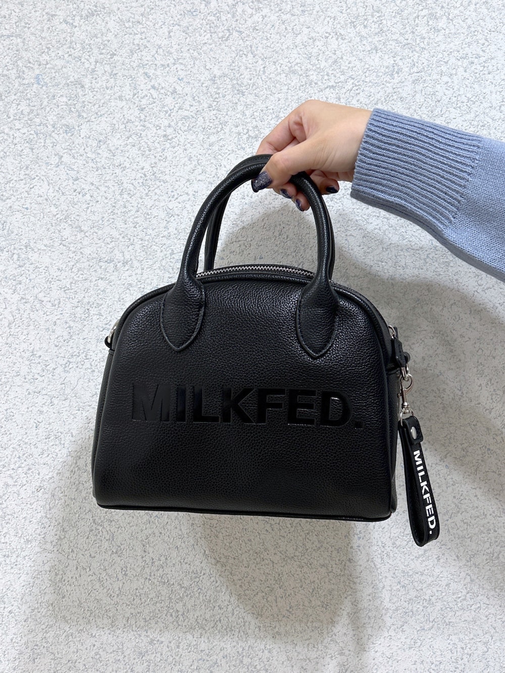 パープル系のカーディガン/ボレロ、ホワイト系のTシャツ/カットソー、ブラック系のサロペット/オーバーオールを着用したレディースの秋コーディネートの4枚目の写真