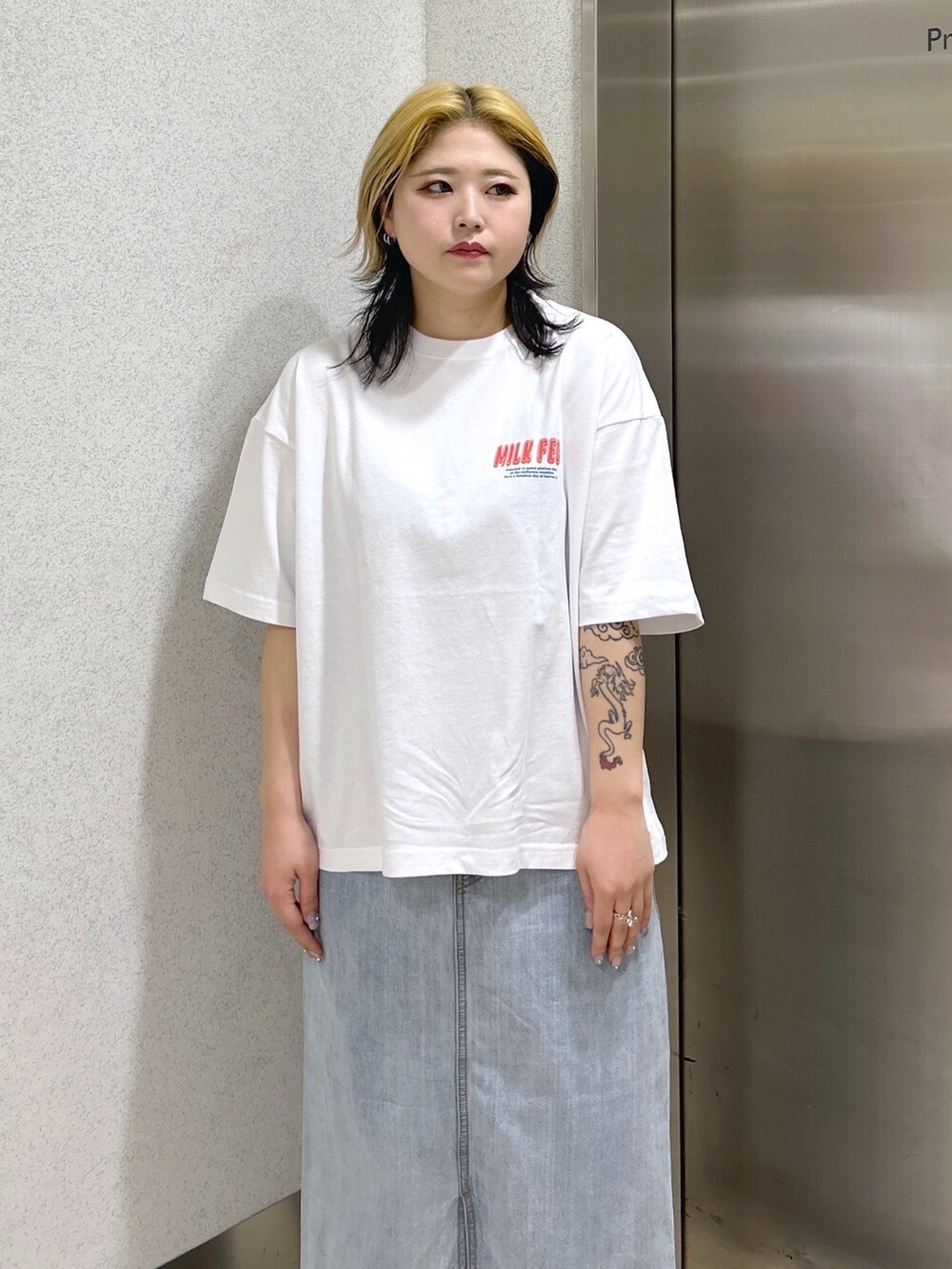 ホワイト系のTシャツ/カットソー、ブラック系のメッセンジャーバッグ、ブルー系のデニムスカートを着用したレディースの春コーディネートの5枚目の写真