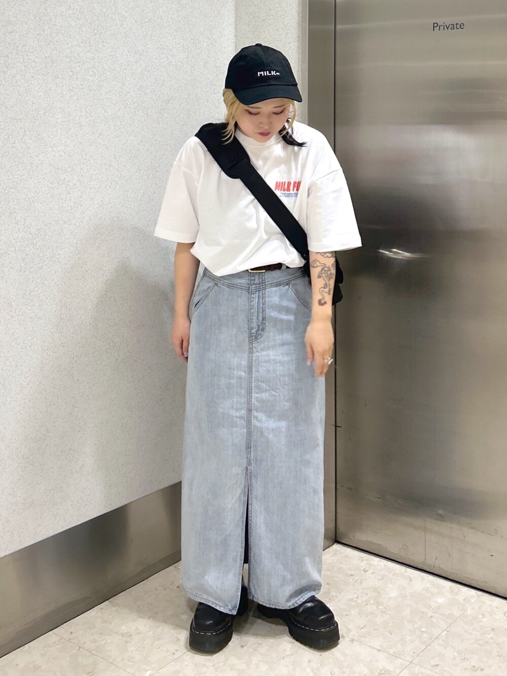 ホワイト系のTシャツ/カットソー、ブラック系のメッセンジャーバッグ、ブルー系のデニムスカートを着用したレディースの春コーディネートの3枚目の写真