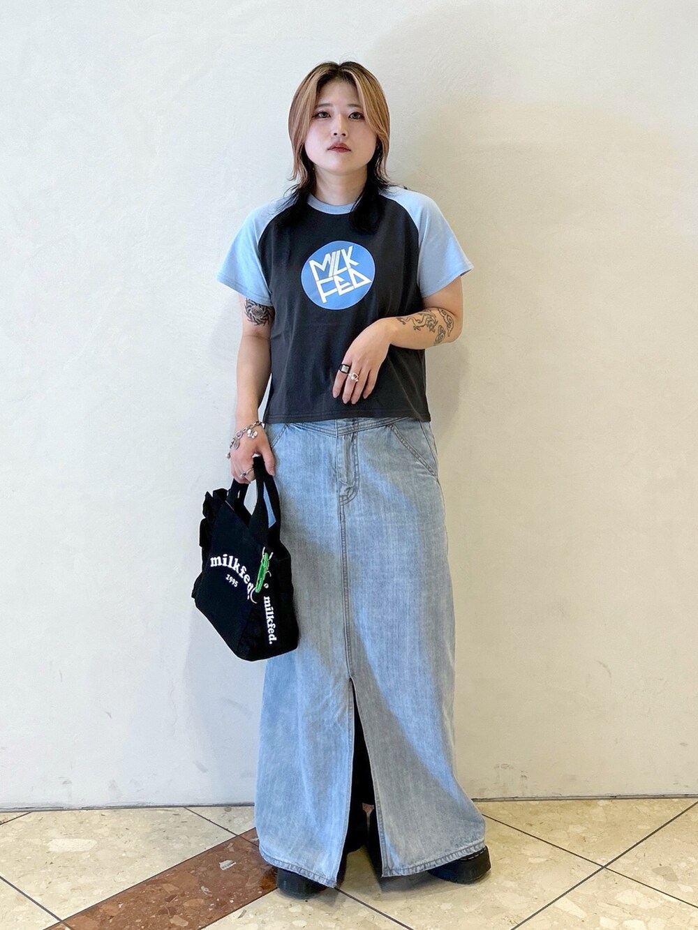 ブルー系のTシャツ/カットソー、ブラック系のショルダーバッグ、ブラック系のブーツを着用したレディースの夏コーディネートの3枚目の写真