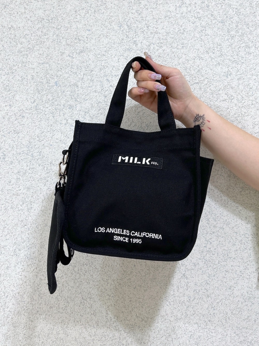 ブルー系のデニムパンツ、ブラック系のショルダーバッグ、ベージュ系のサンダルを着用したレディースの夏コーディネートの6枚目の写真