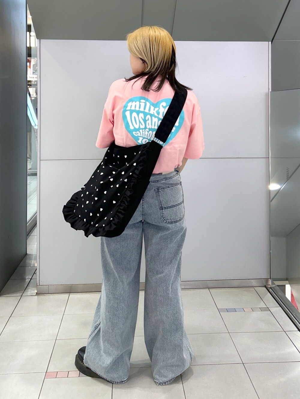 ピンク系のTシャツ/カットソー、ブルー系のデニムパンツ、ブラック系のショルダーバッグを着用したレディースの春コーディネートの4枚目の写真