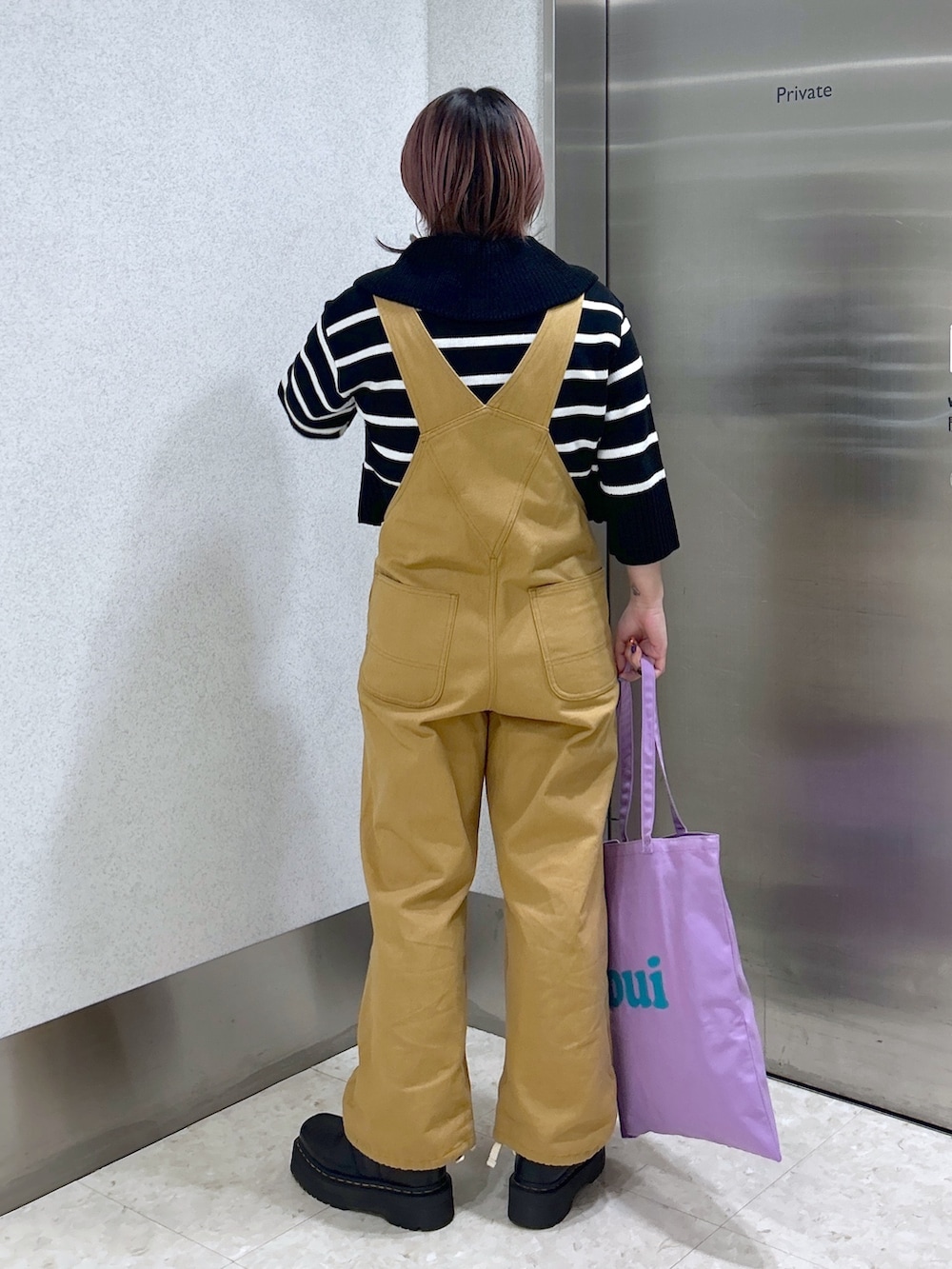 ベージュ系のサロペット/オーバーオール、パープル系のトートバッグ、ブラック系のカーディガン/ボレロを着用したレディースの春コーディネートの2枚目の写真