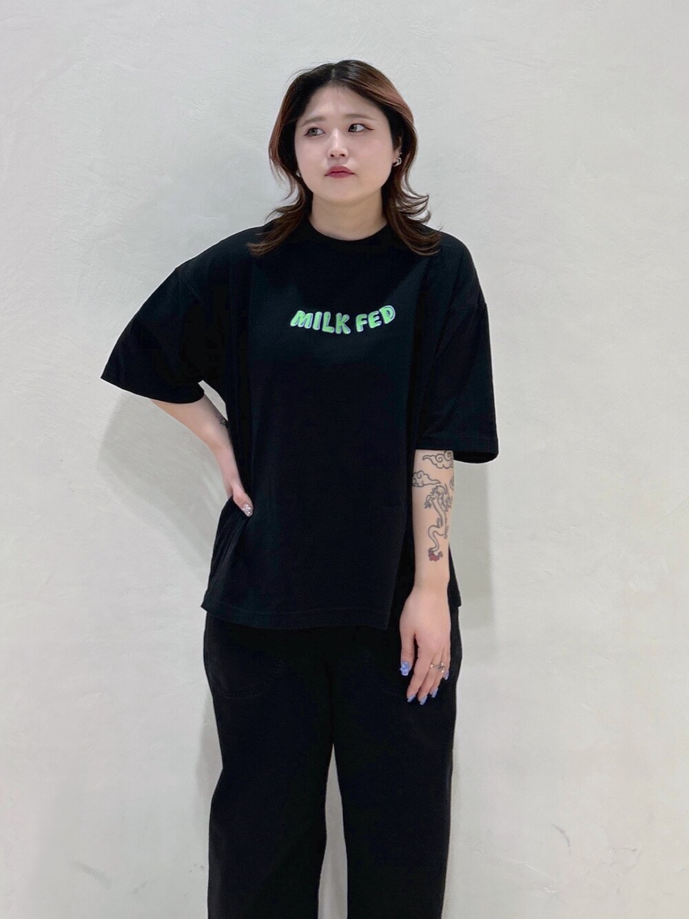 ブラック系のTシャツ/カットソー、ブルー系のハンドバッグ、ブラック系のブーツを着用したレディースの春コーディネートの5枚目の写真