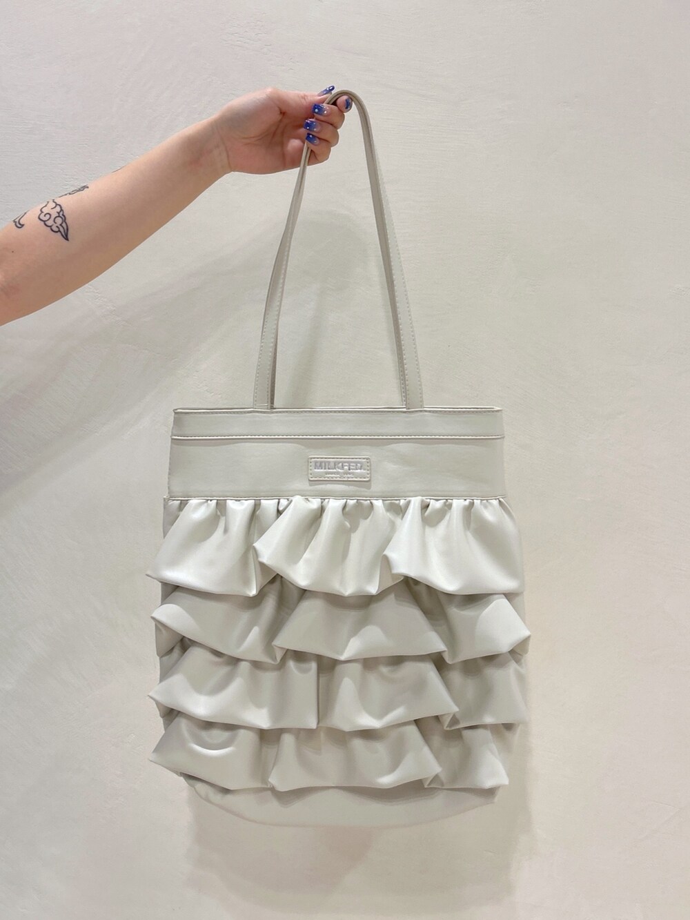 ブルー系のTシャツ/カットソー、ブルー系のデニムスカート、ホワイト系のトートバッグを着用したレディースの夏コーディネートの7枚目の写真