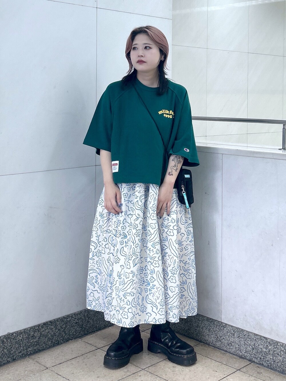 ホワイト系のワンピース、ブラック系のブーツ、グリーン系のショルダーバッグを着用したレディースの夏コーディネートの2枚目の写真