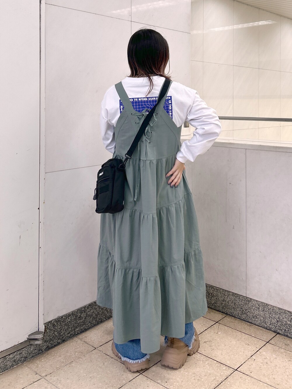 ホワイト系のTシャツ/カットソー、グリーン系のワンピース、ブラック系のショルダーバッグを着用したレディースの秋コーディネートの3枚目の写真