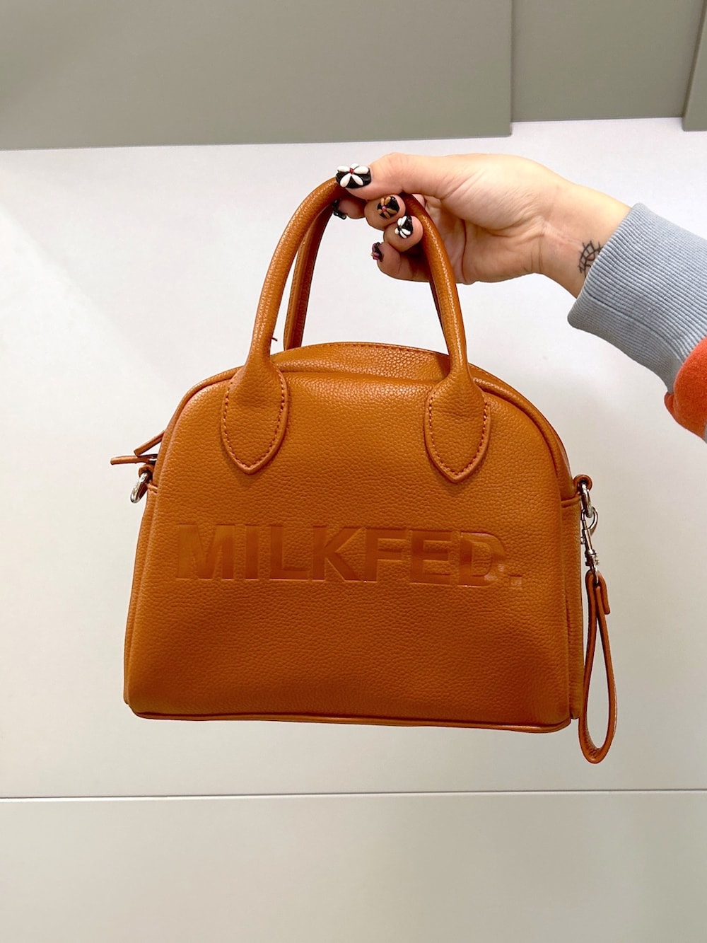 ホワイト系のベスト、ベージュ系のスニーカー、ピンク系のスウェットを着用したレディースの冬コーディネートの5枚目の写真