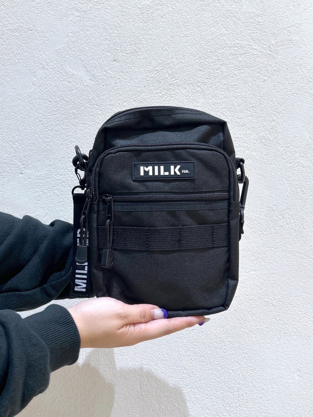 ブラック系のパーカー、ブラック系のショルダーバッグ、ブラック系のカーゴパンツを着用したレディースの秋コーディネートの5枚目の写真