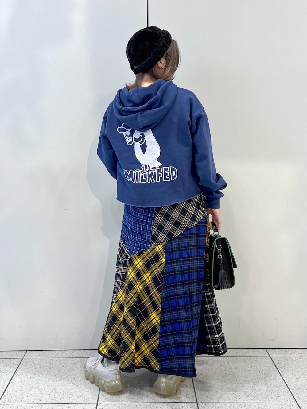 ブルー系のパーカー、ブラック系のスカート、ブラック系のショルダーバッグを着用したレディースの秋コーディネートの2枚目の写真