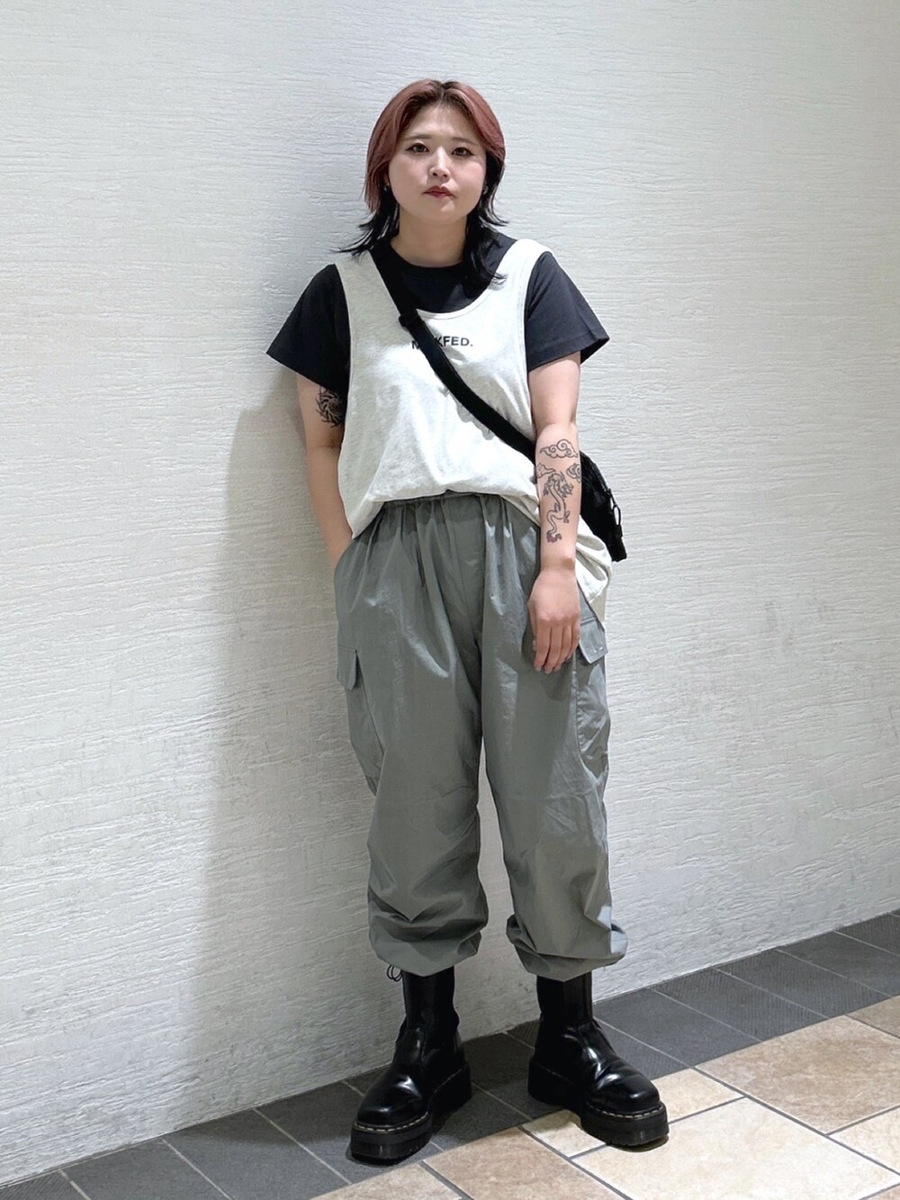 グレー系のTシャツ/カットソー、グリーン系のショルダーバッグ、ベージュ系のタンクトップを着用したレディースの春コーディネートの3枚目の写真