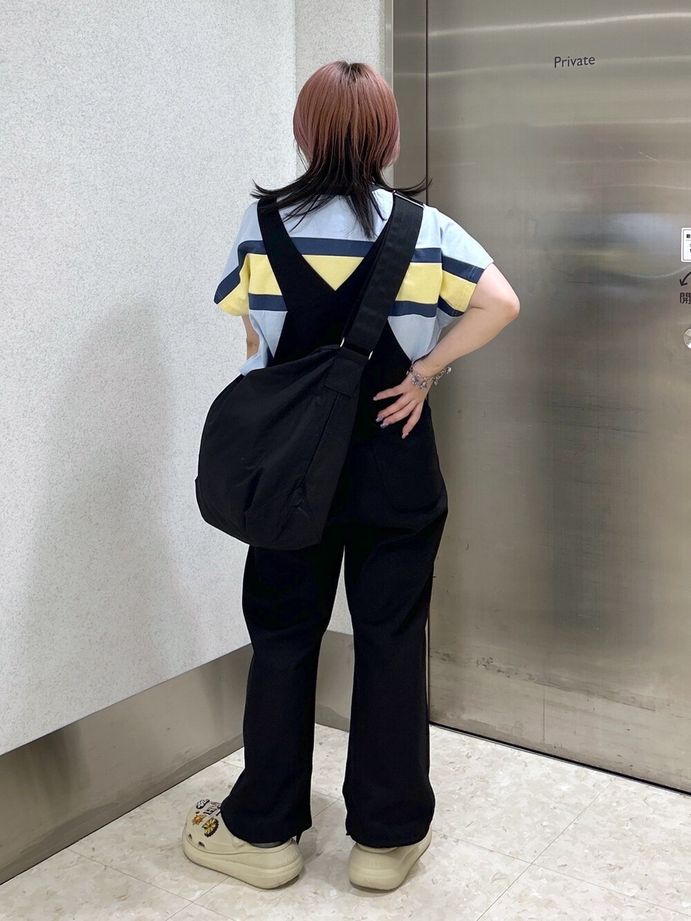 ブラック系のサロペット/オーバーオール、ブラック系のショルダーバッグ、ベージュ系のサンダルを着用したレディースの夏コーディネートの3枚目の写真