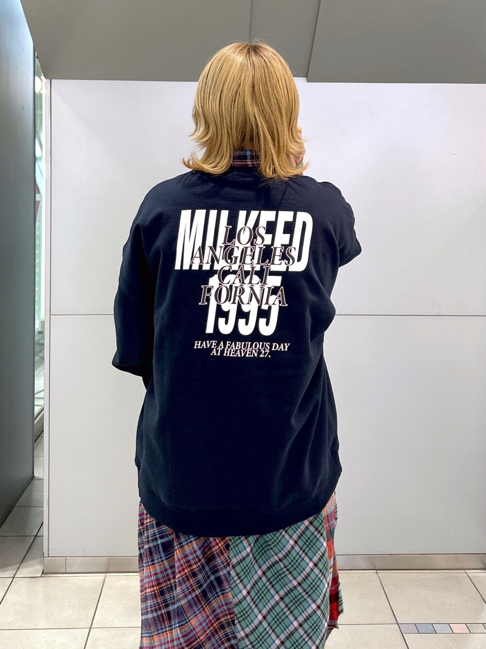 ブルー系のスウェット、ブラウン系のボストンバッグ、グリーン系のシャツワンピースを着用したレディースの秋コーディネートの4枚目の写真