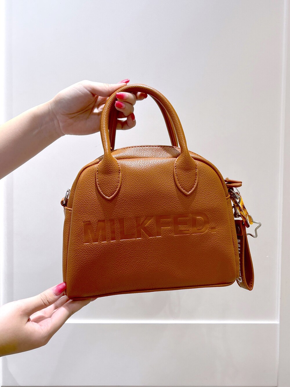 パープル系のシャツ/ブラウス、ブラック系のスカート、ブラウン系のボストンバッグを着用したレディースの夏コーディネートの4枚目の写真