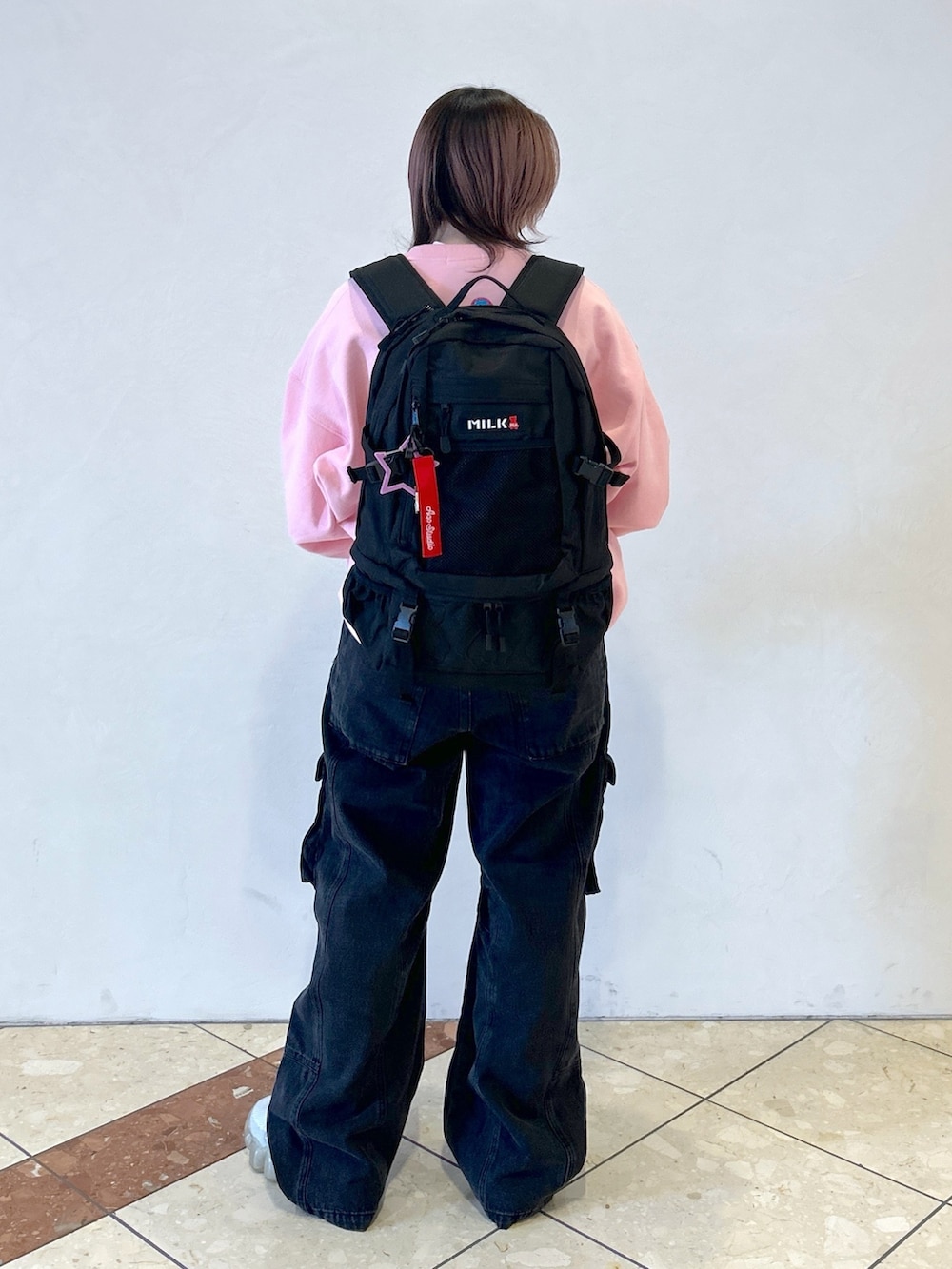 ブラック系のバックパック/リュック、ピンク系のスウェット、ブラック系のカーゴパンツを着用したレディースの春コーディネートの5枚目の写真