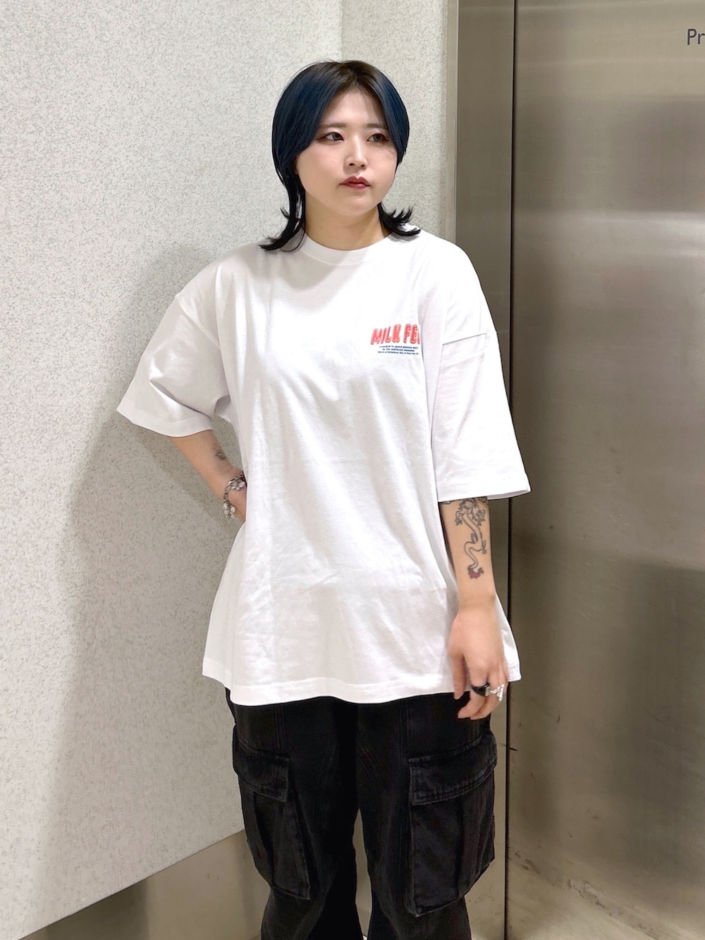 ブラック系のカーゴパンツ、ブラック系のショルダーバッグ、ホワイト系のTシャツ/カットソーを着用したレディースの夏コーディネートの6枚目の写真