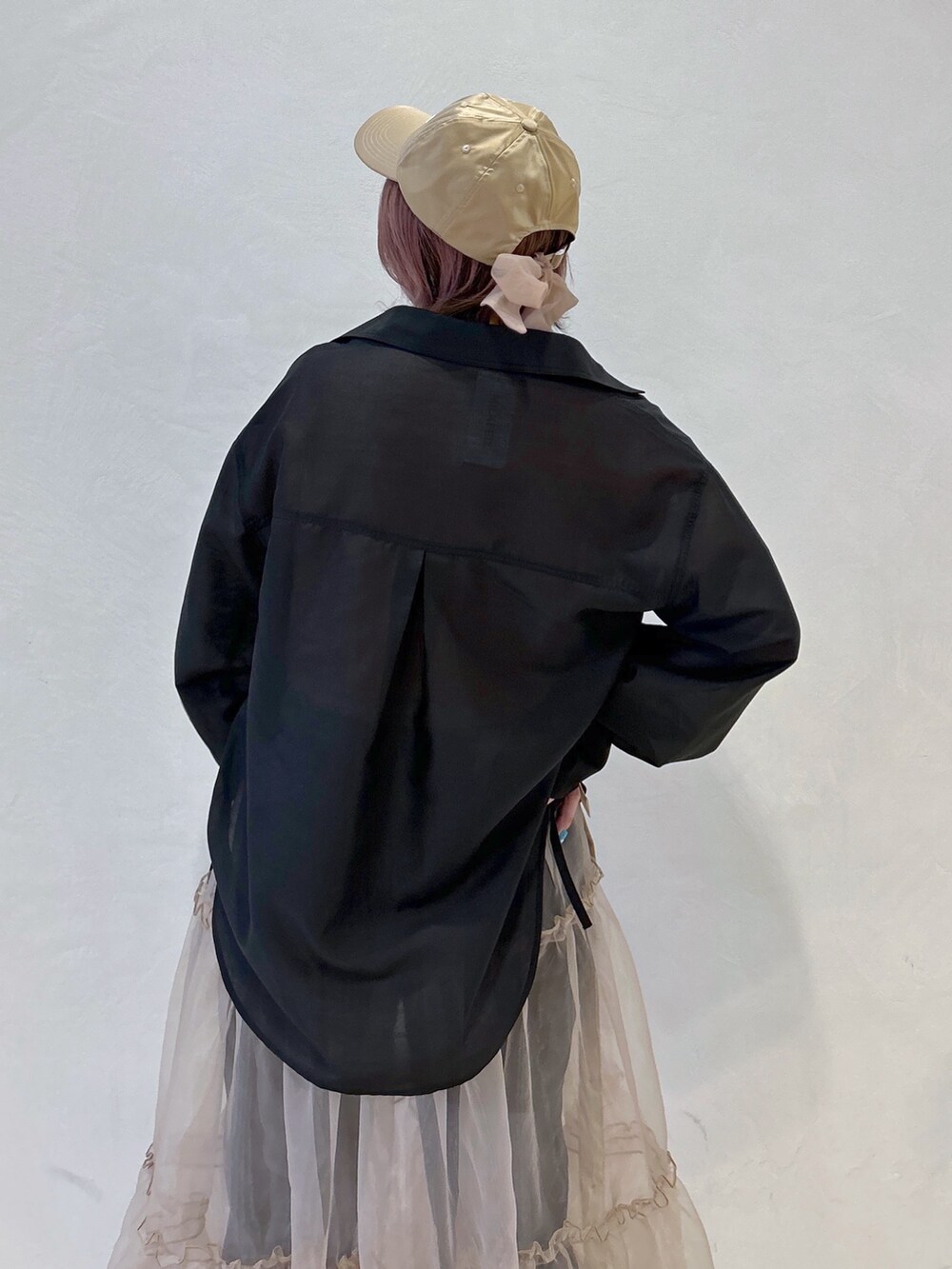 オレンジ系のTシャツ/カットソー、ブラック系のシャツ/ブラウス、ベージュ系のスカートを着用したレディースの冬コーディネートの6枚目の写真