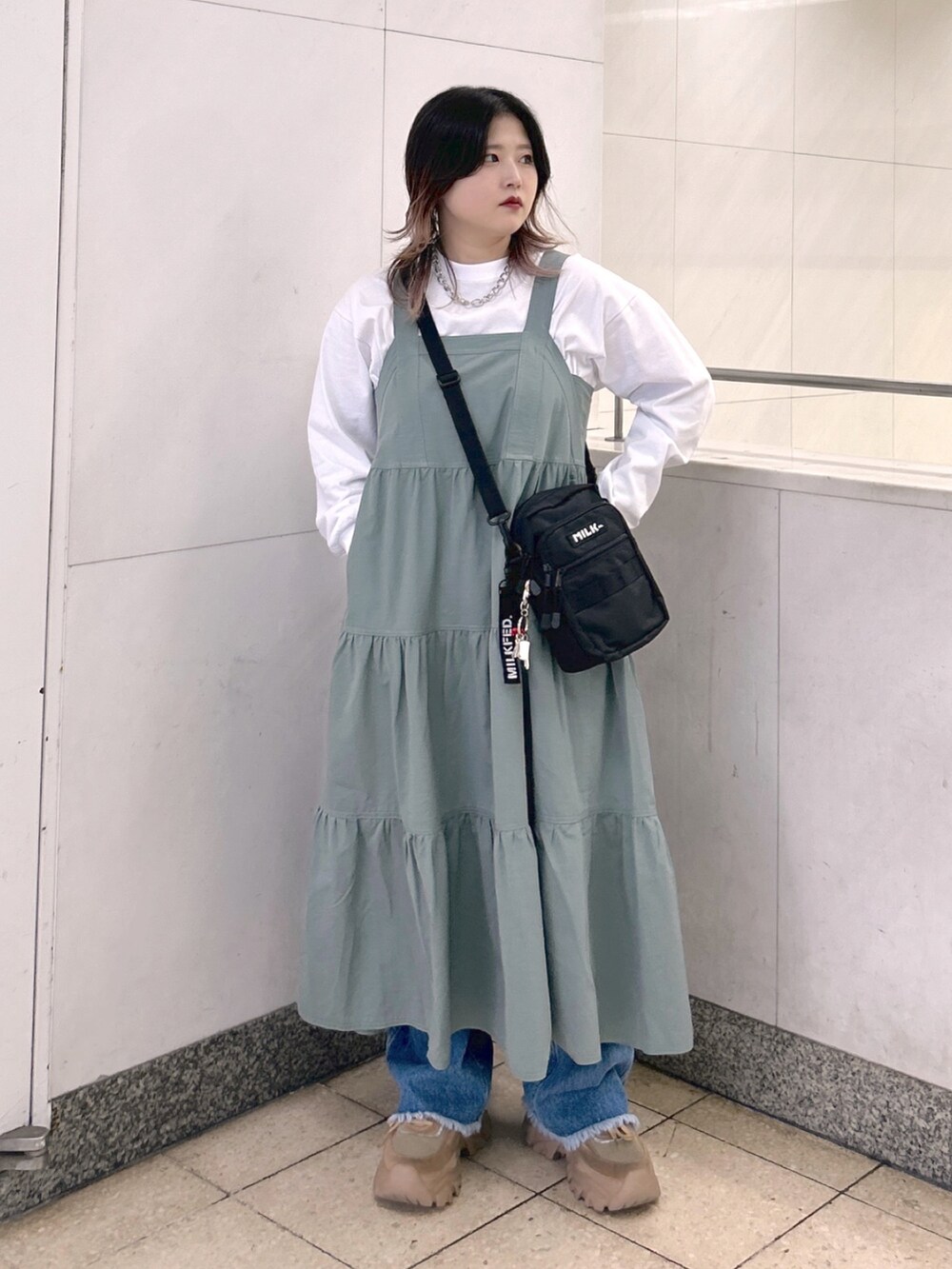 ホワイト系のTシャツ/カットソー、グリーン系のワンピース、ブラック系のショルダーバッグを着用したレディースの秋コーディネートの2枚目の写真