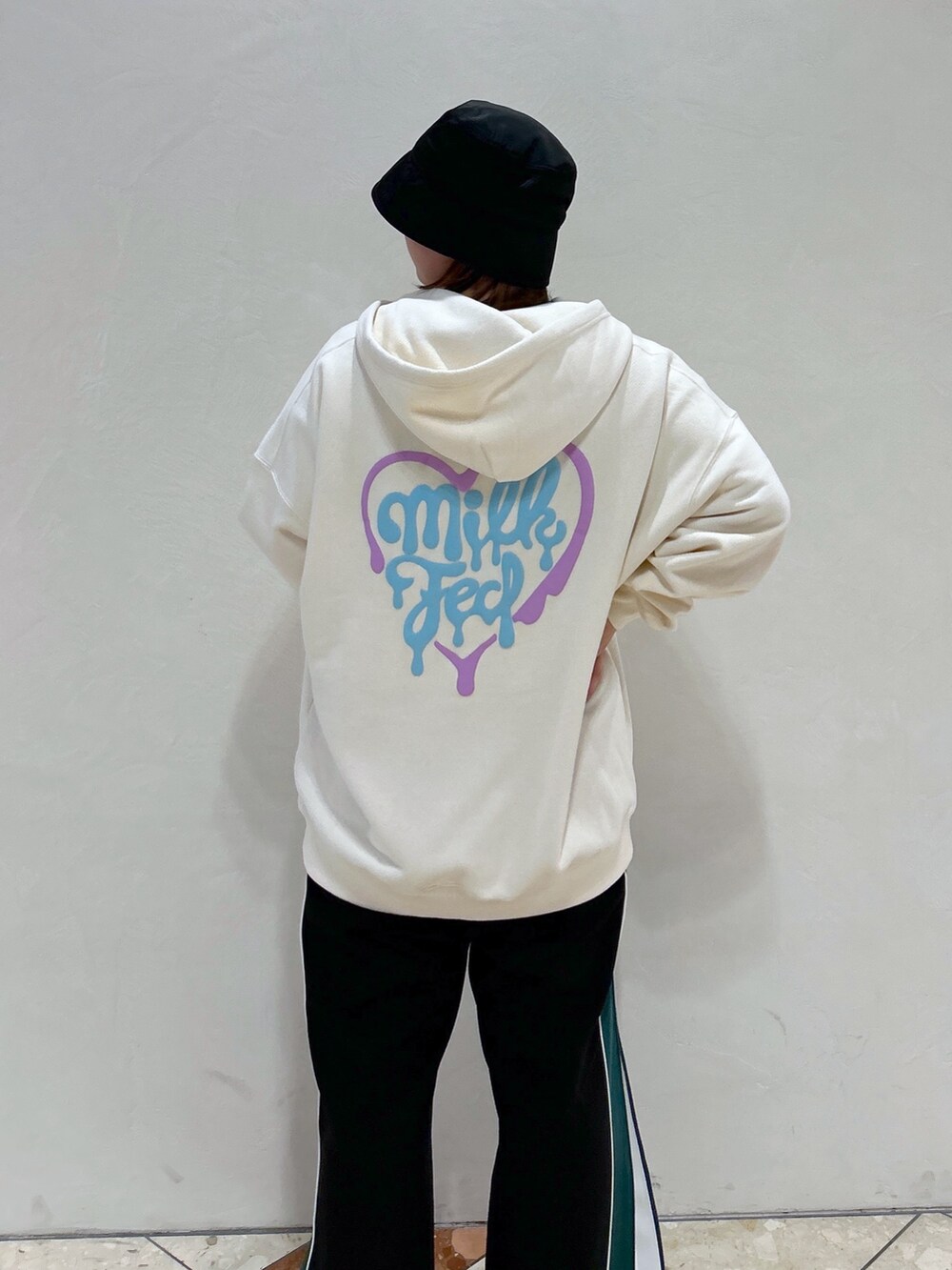 ホワイト系のパーカー、ブラック系のその他パンツ、グリーン系のトートバッグを着用したレディースの春コーディネートの5枚目の写真