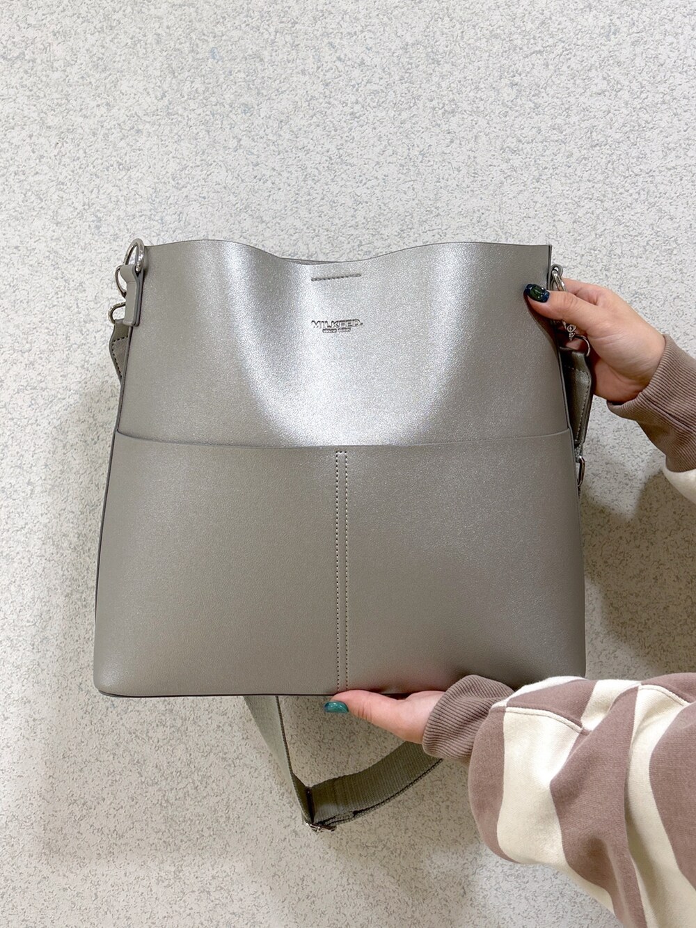 グレー系のスウェット、ブラック系のワンピース、ブラック系のブーツを着用したレディースの冬コーディネートの5枚目の写真