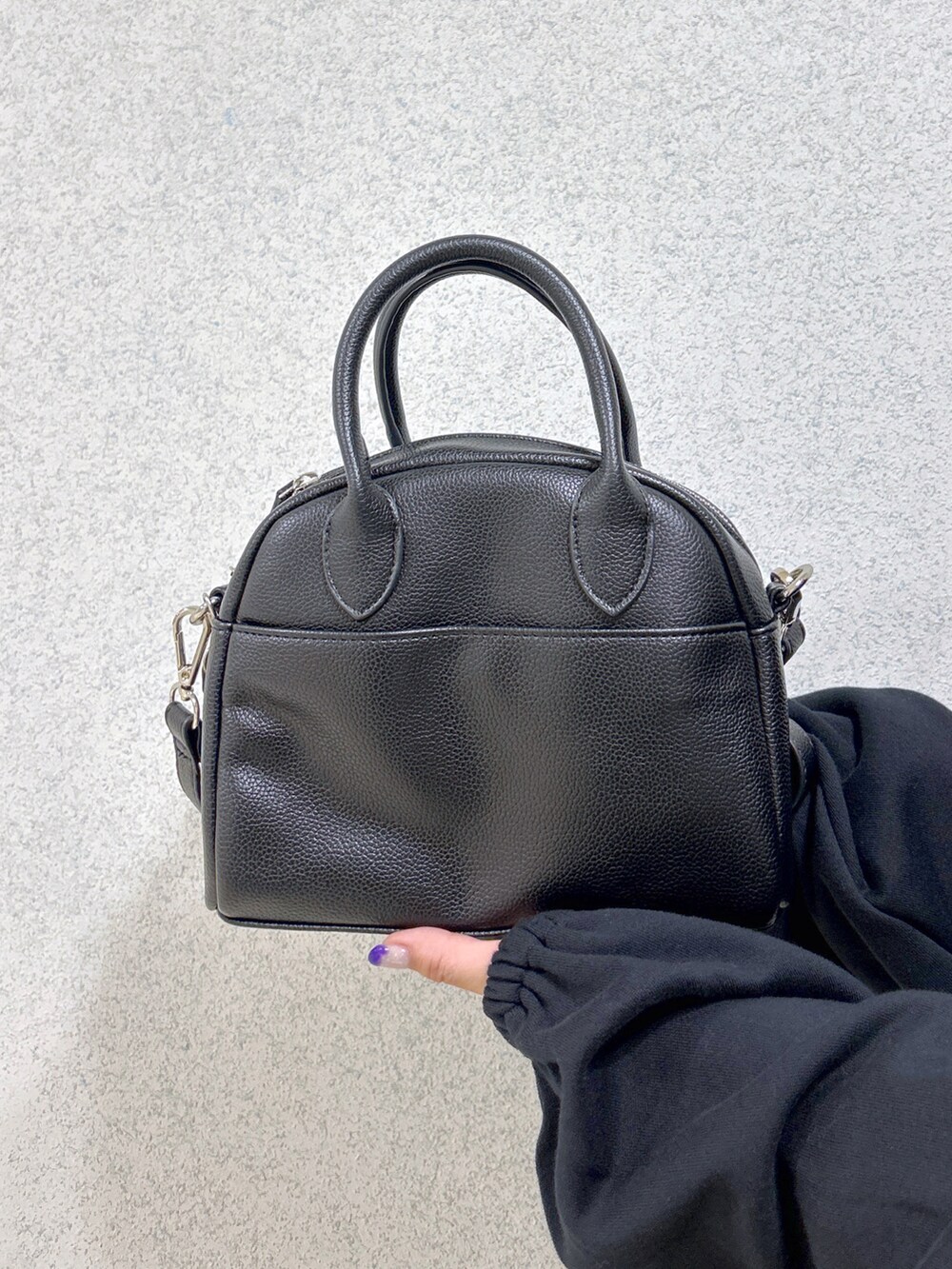 ブラック系のスウェット、ブラック系のボストンバッグ、グリーン系のTシャツ/カットソーを着用したレディースの秋コーディネートの5枚目の写真