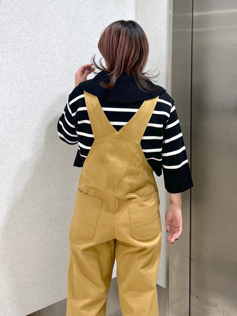 ベージュ系のサロペット/オーバーオール、パープル系のトートバッグ、ブラック系のカーディガン/ボレロを着用したレディースの春コーディネートの4枚目の写真