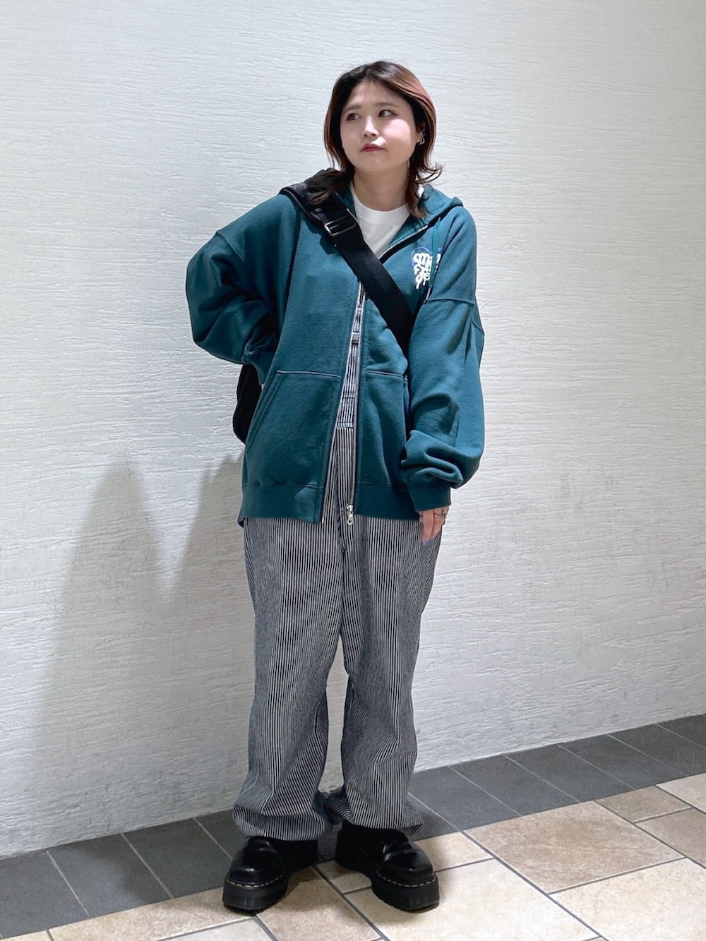 グリーン系のパーカー、その他のサロペット/オーバーオール、ブラック系のメッセンジャーバッグを着用したレディースの春コーディネートの3枚目の写真