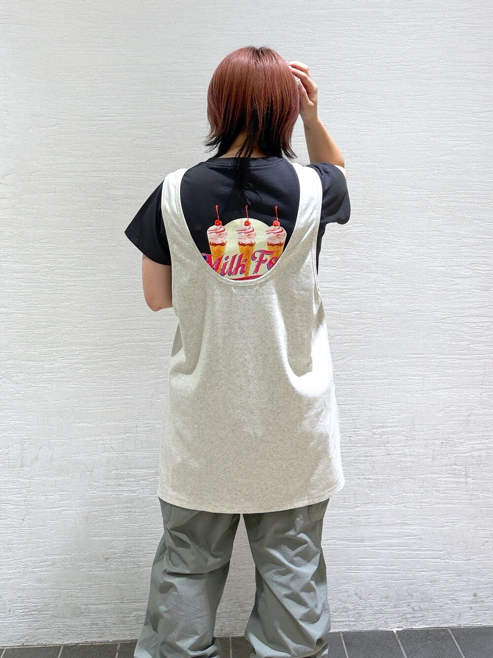 グレー系のTシャツ/カットソー、グリーン系のショルダーバッグ、ベージュ系のタンクトップを着用したレディースの春コーディネートの4枚目の写真