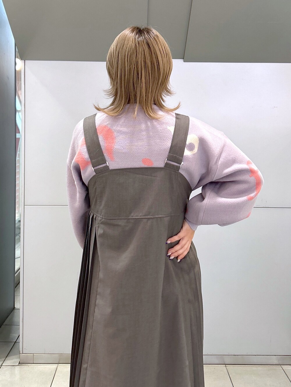 パープル系のニット/セーター、グレー系のジャンパースカート、ブラック系のショルダーバッグを着用したレディースの秋コーディネートの4枚目の写真