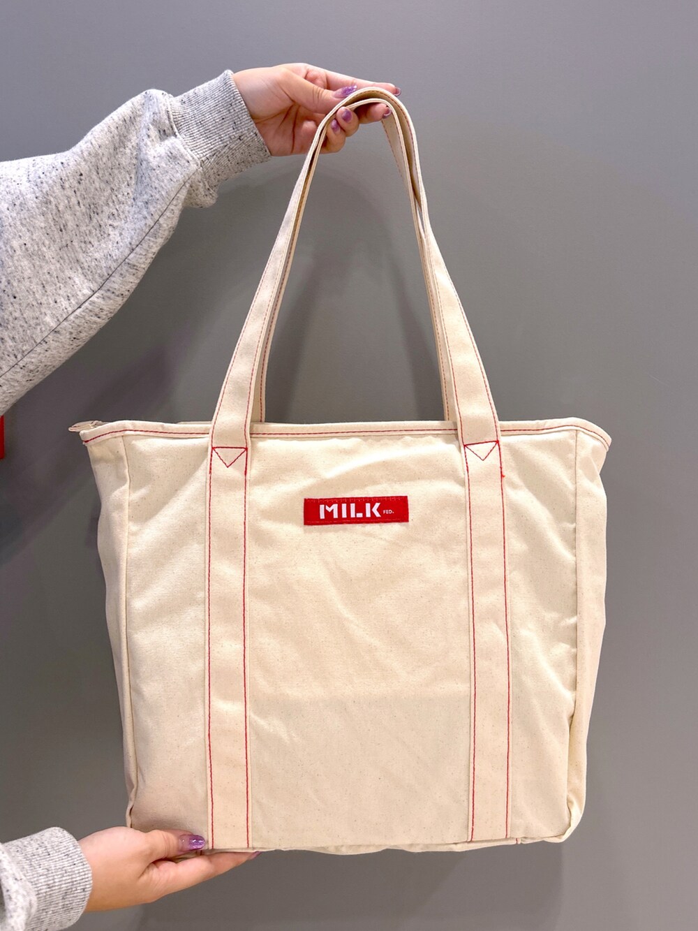 その他のパーカー、レッド系のスカート、レッド系のトートバッグを着用したレディースの秋コーディネートの5枚目の写真