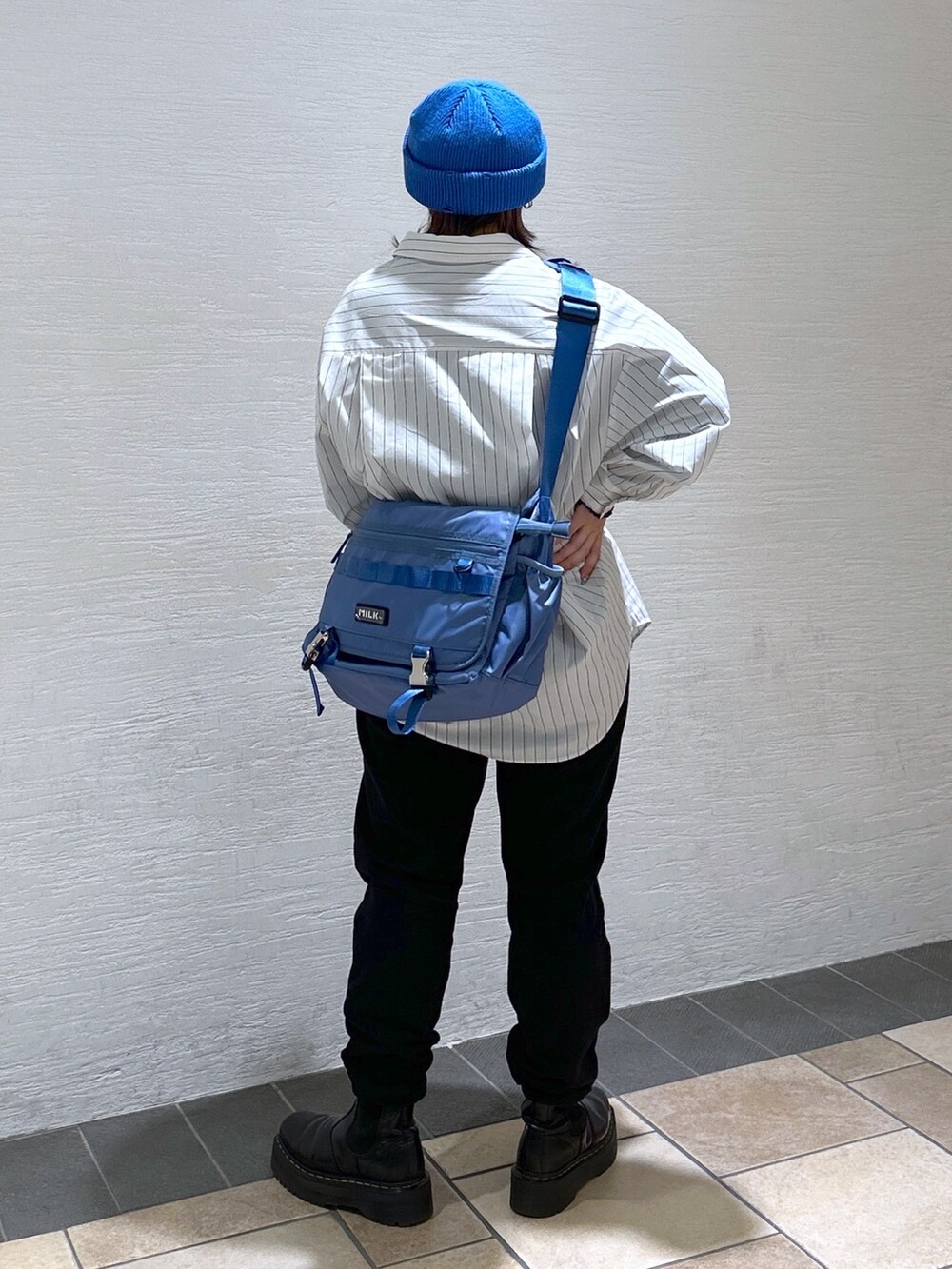 ホワイト系のシャツ/ブラウス、ブルー系のメッセンジャーバッグ、ブラック系のスウェットパンツを着用したレディースの冬コーディネートの5枚目の写真