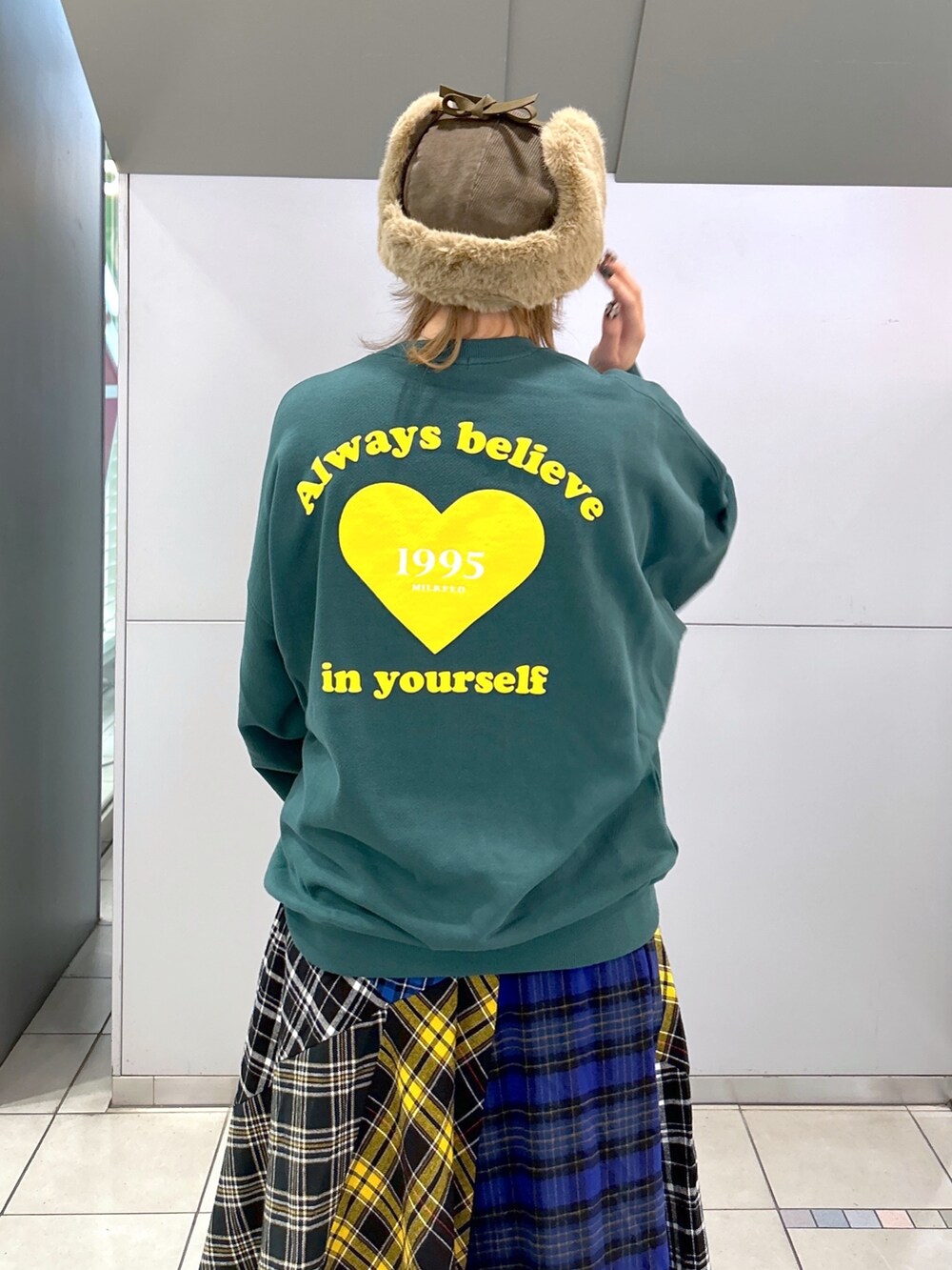 グリーン系のスウェット、グリーン系のMA-1、ブラック系のスカートを着用したレディースの冬コーディネートの4枚目の写真