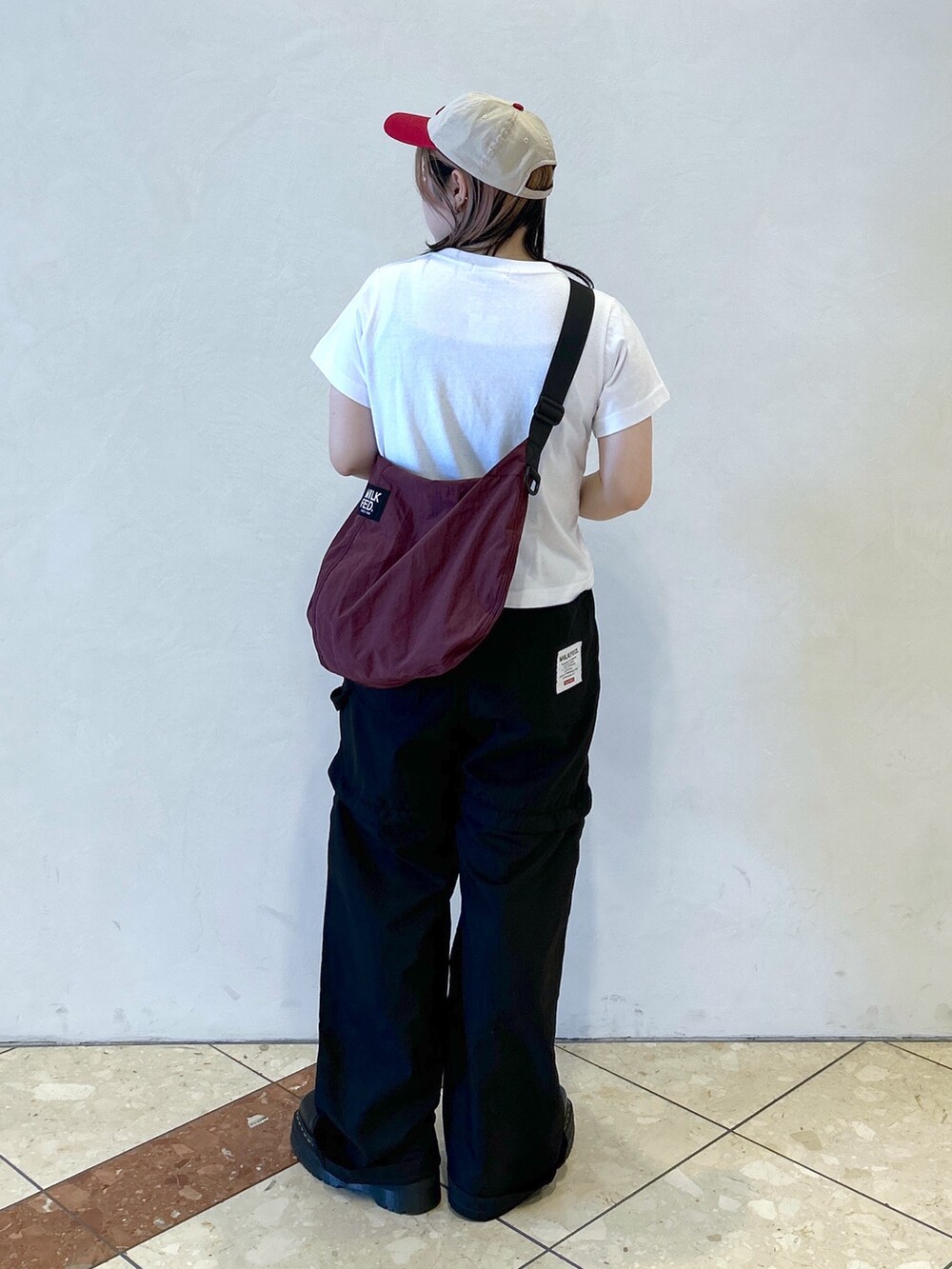 ブラック系のその他パンツ、レッド系のショルダーバッグ、ホワイト系のTシャツ/カットソーを着用したレディースの夏コーディネートの5枚目の写真