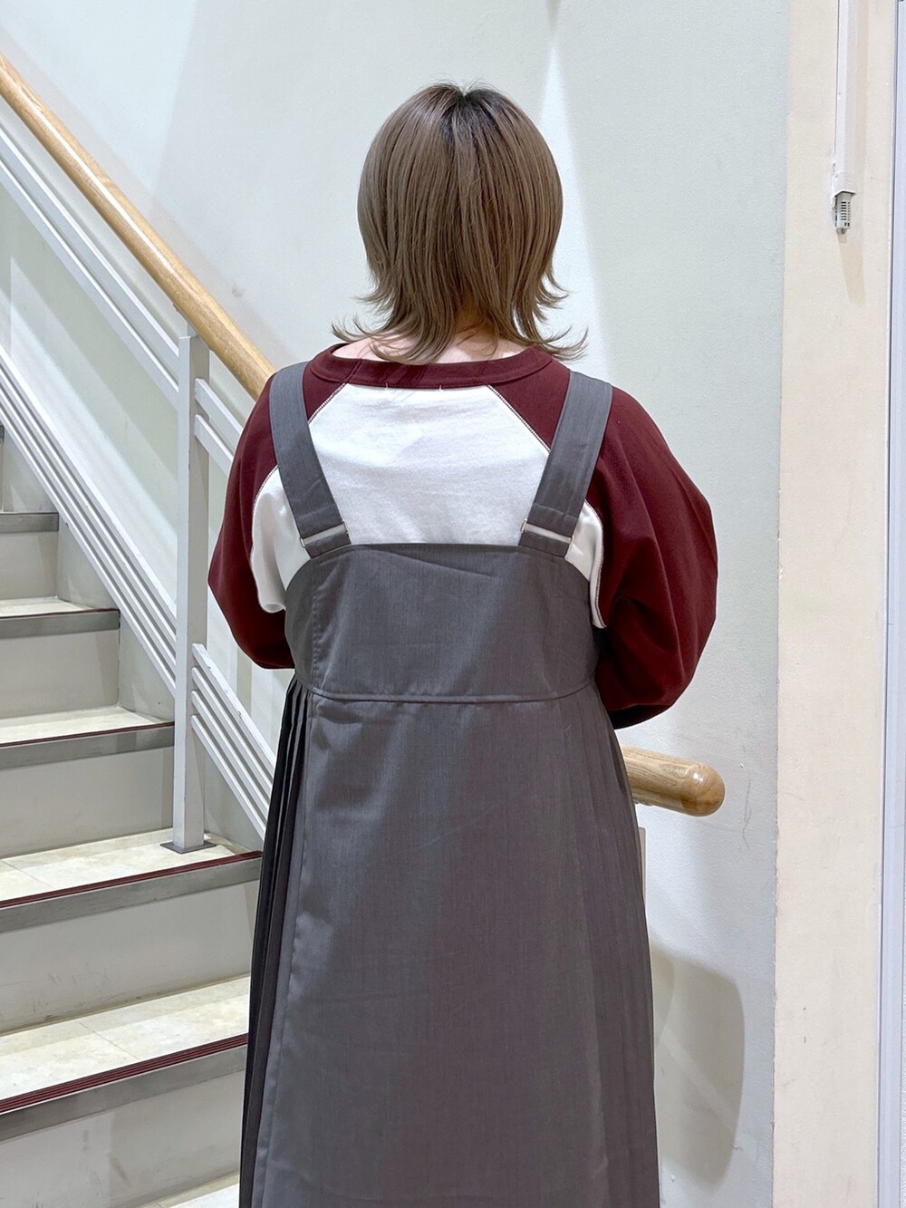 ブラウン系のTシャツ/カットソー、シルバー系のショルダーバッグ、グレー系のジャンパースカートを着用したレディースの秋コーディネートの4枚目の写真