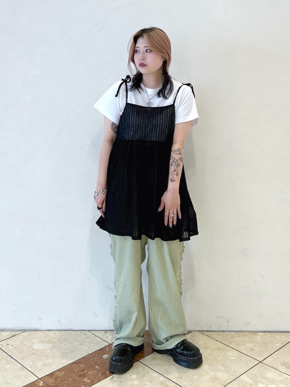 ブラック系のキャミソール、グリーン系のその他パンツ、ブラック系のブーツを着用したレディースの夏コーディネートの2枚目の写真