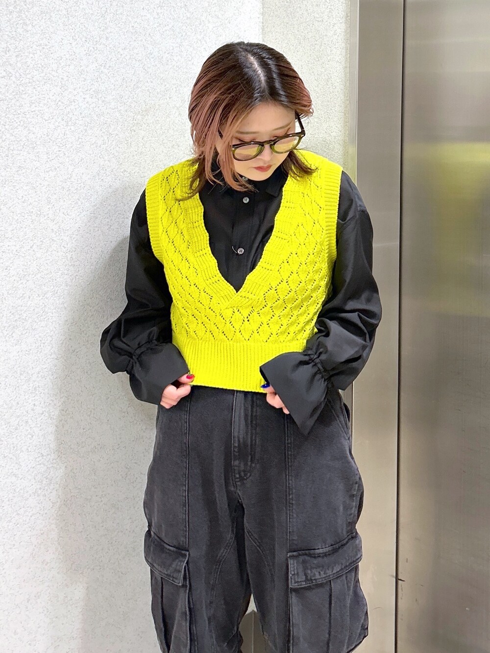 ブラック系のシャツ/ブラウス、イエロー系のベスト、ブラック系のカーゴパンツを着用したレディースの春コーディネートの5枚目の写真