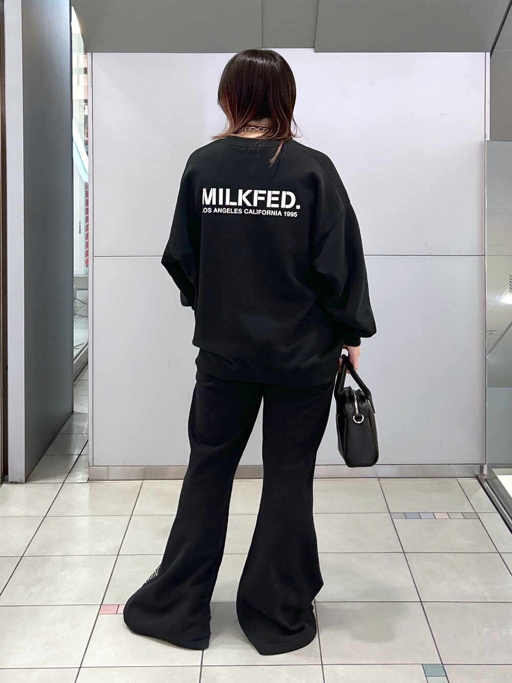 ブラック系のスウェット、ブラック系のスウェットパンツ、ブラック系のボストンバッグを着用したレディースの秋コーディネートの2枚目の写真