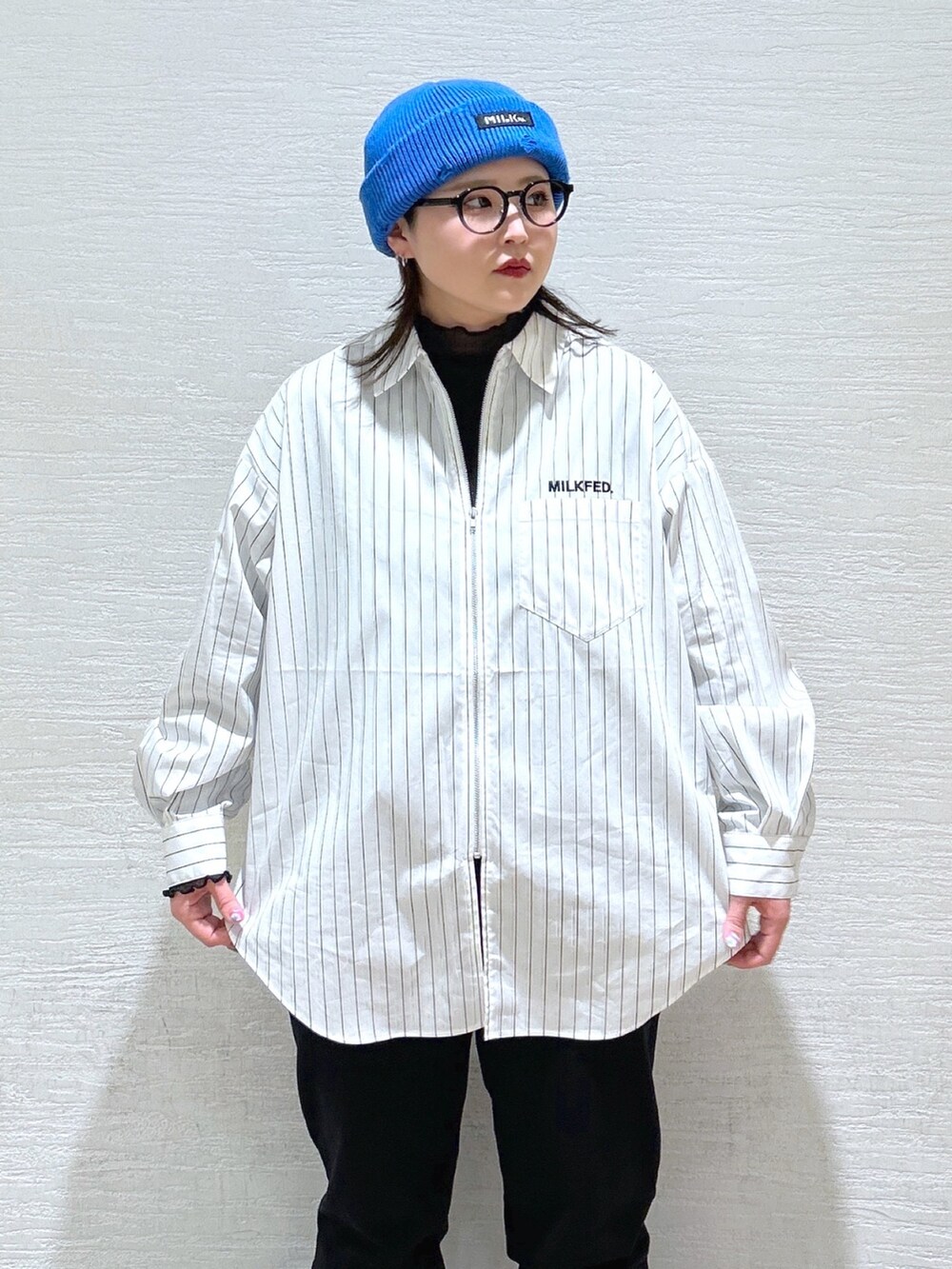 ホワイト系のシャツ/ブラウス、ブルー系のメッセンジャーバッグ、ブラック系のスウェットパンツを着用したレディースの冬コーディネートの6枚目の写真