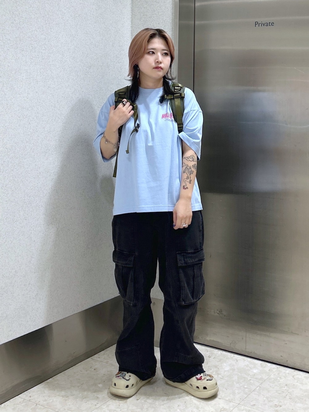 ブルー系のTシャツ/カットソー、ブラック系のカーゴパンツ、グリーン系のバックパック/リュックを着用したレディースの夏コーディネートの2枚目の写真