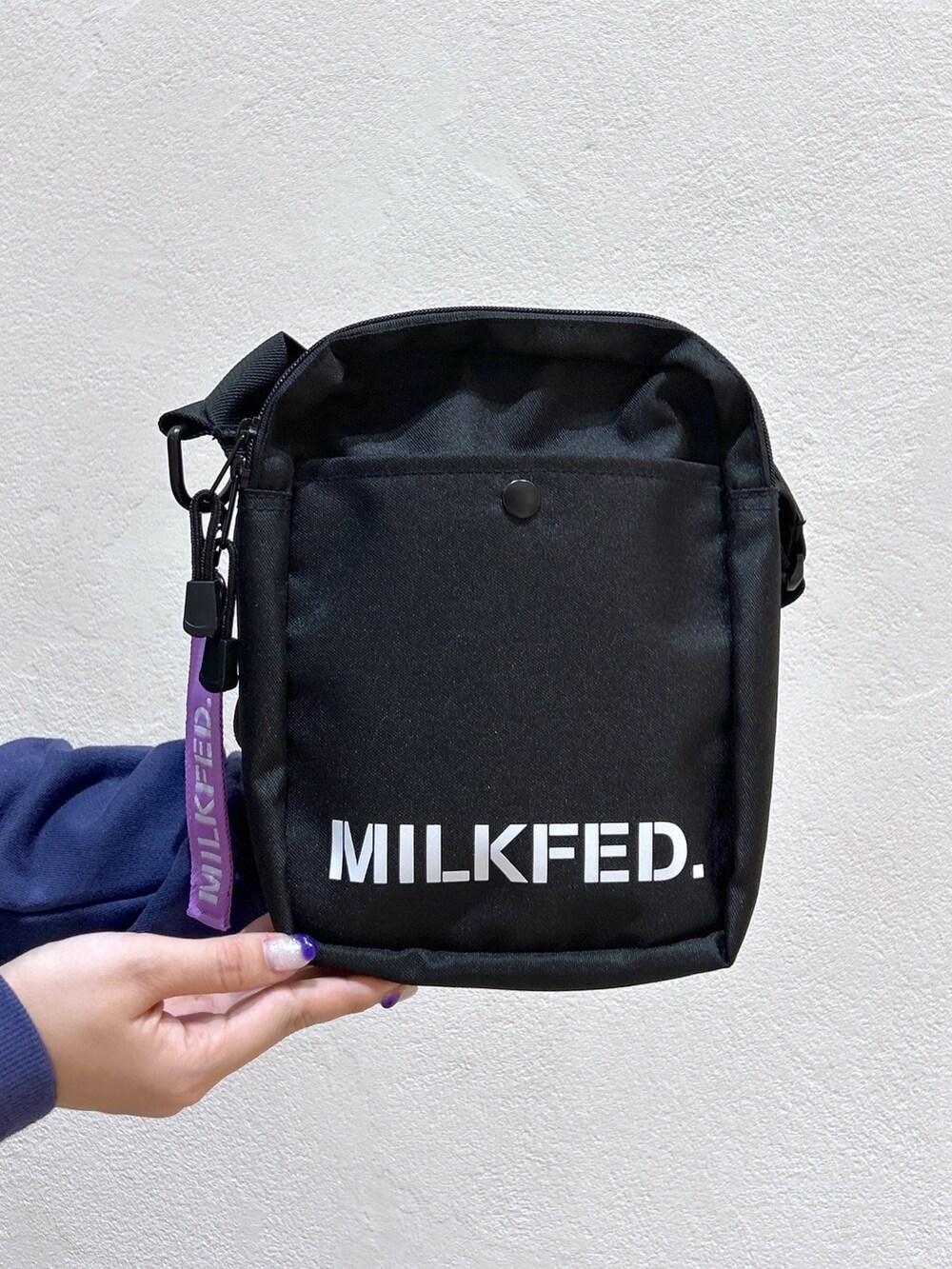 ブルー系のスウェット、ブラック系のスカート、パープル系のショルダーバッグを着用したレディースの秋コーディネートの5枚目の写真