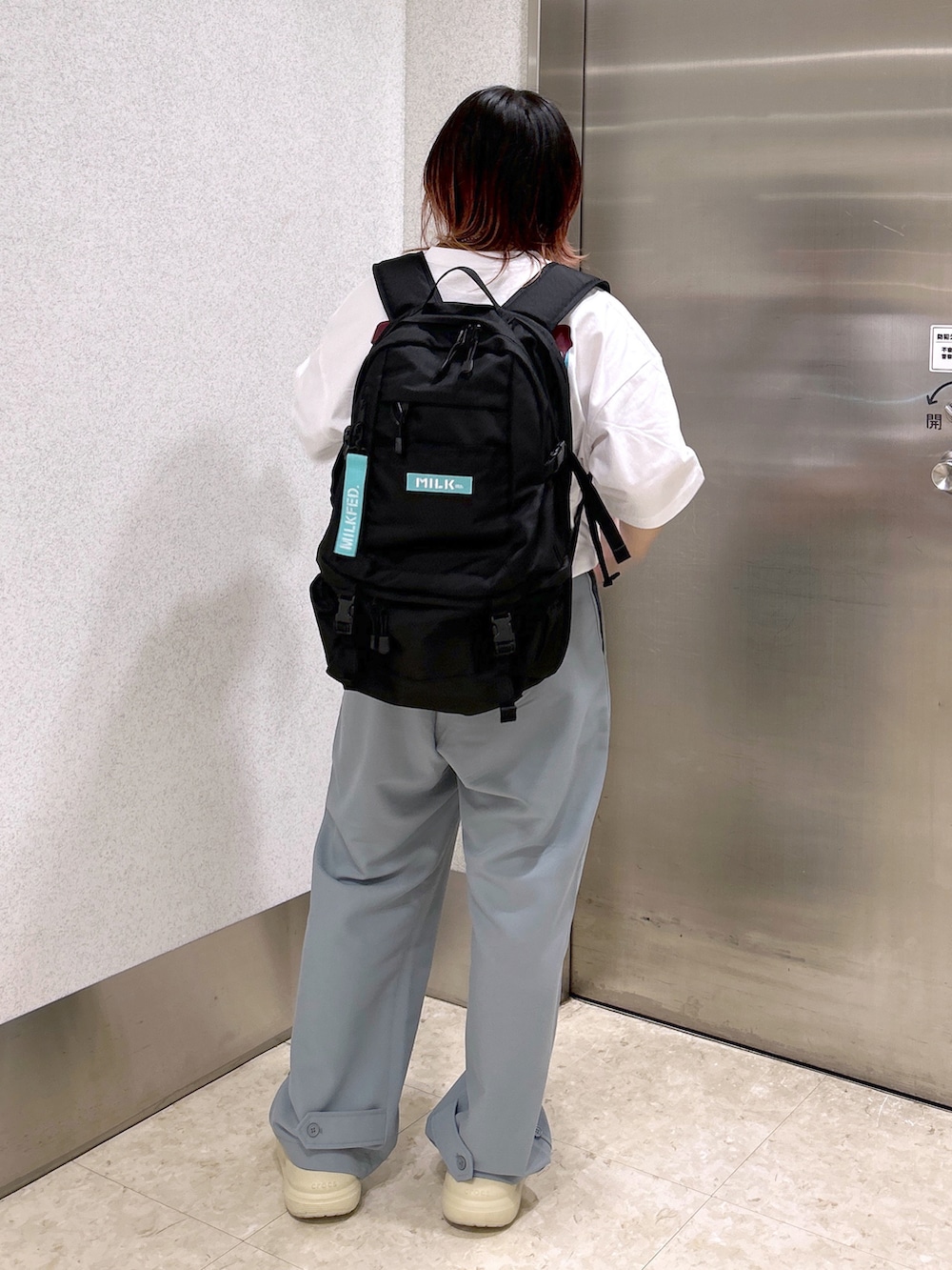 ホワイト系のTシャツ/カットソー、ブルー系のその他パンツ、ブラック系のバックパック/リュックを着用したレディースの夏コーディネートの3枚目の写真