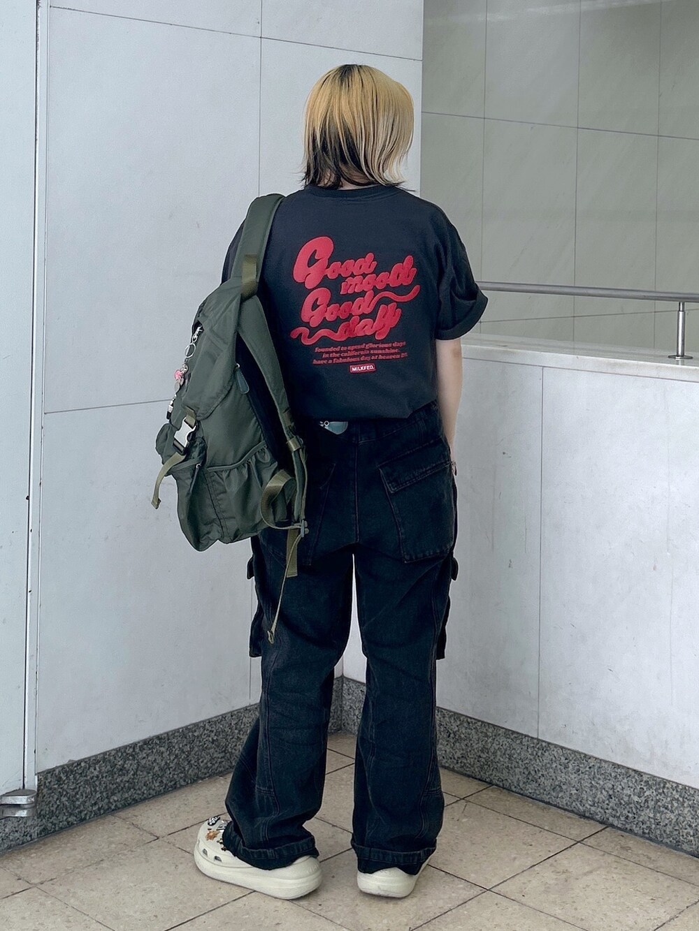 グレー系のTシャツ/カットソー、グリーン系のバックパック/リュック、ブラック系のカーゴパンツを着用したレディースの春コーディネートの2枚目の写真