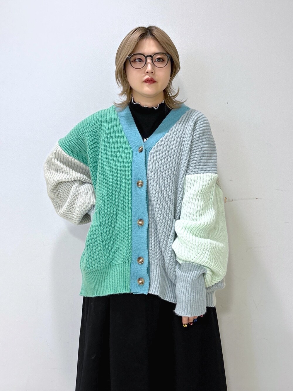 グリーン系のカーディガン/ボレロ、ブラック系のその他トップス、ブラック系のジャンパースカートを着用したレディースの秋コーディネートの4枚目の写真