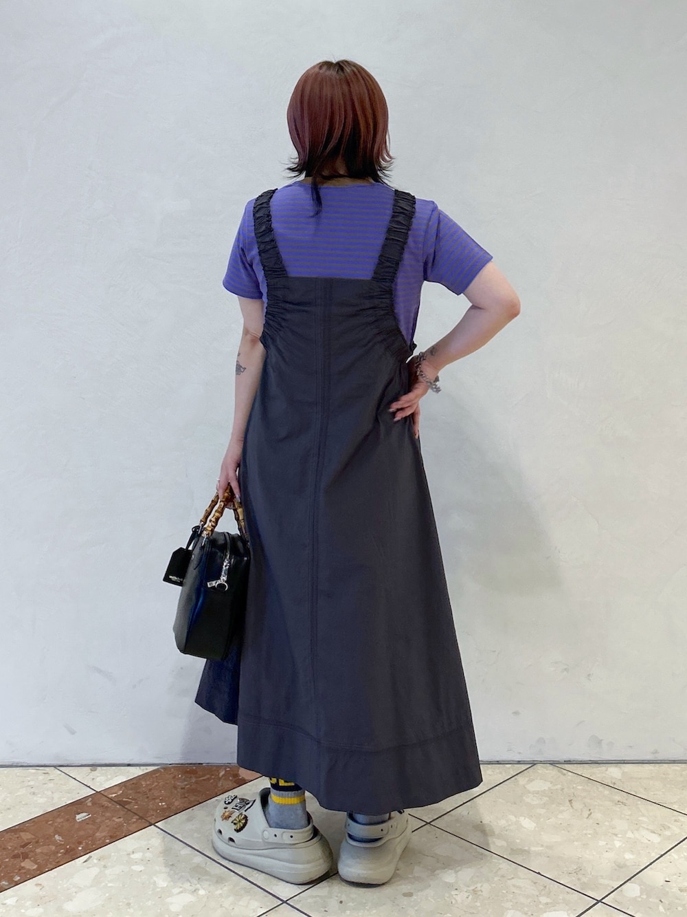 パープル系のTシャツ/カットソー、グレー系のワンピース、ブラック系のショルダーバッグを着用したレディースの春コーディネートの4枚目の写真