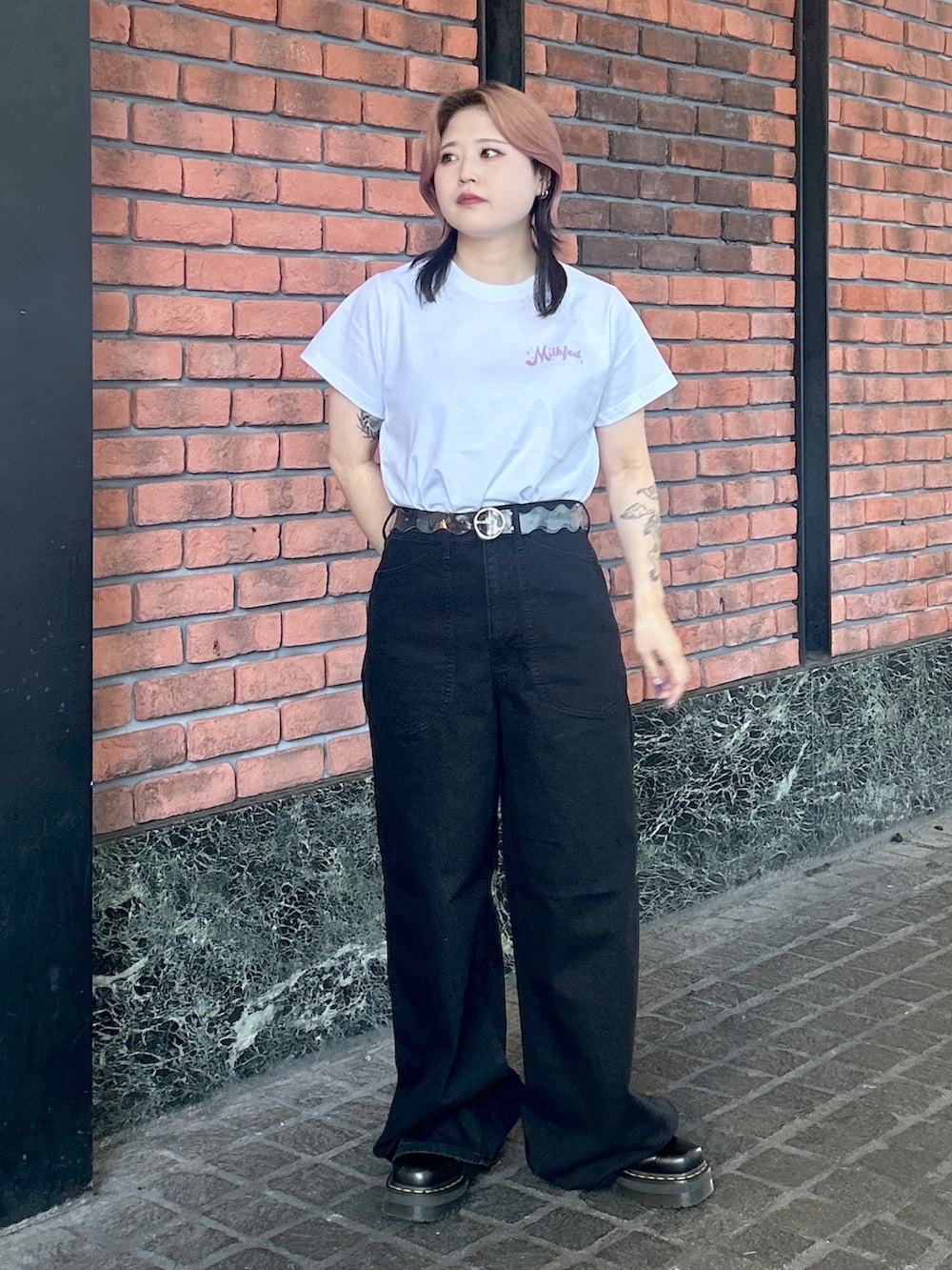 ブラック系のブーツ、ホワイト系のTシャツ/カットソー、ブラック系のデニムパンツを着用したレディースの夏コーディネートの2枚目の写真