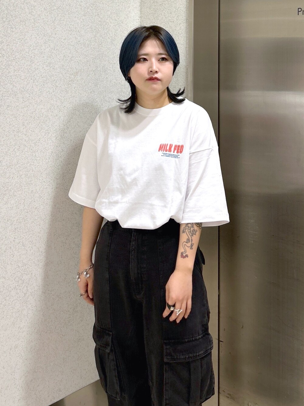 ブラック系のカーゴパンツ、ブラック系のショルダーバッグ、ホワイト系のTシャツ/カットソーを着用したレディースの夏コーディネートの4枚目の写真