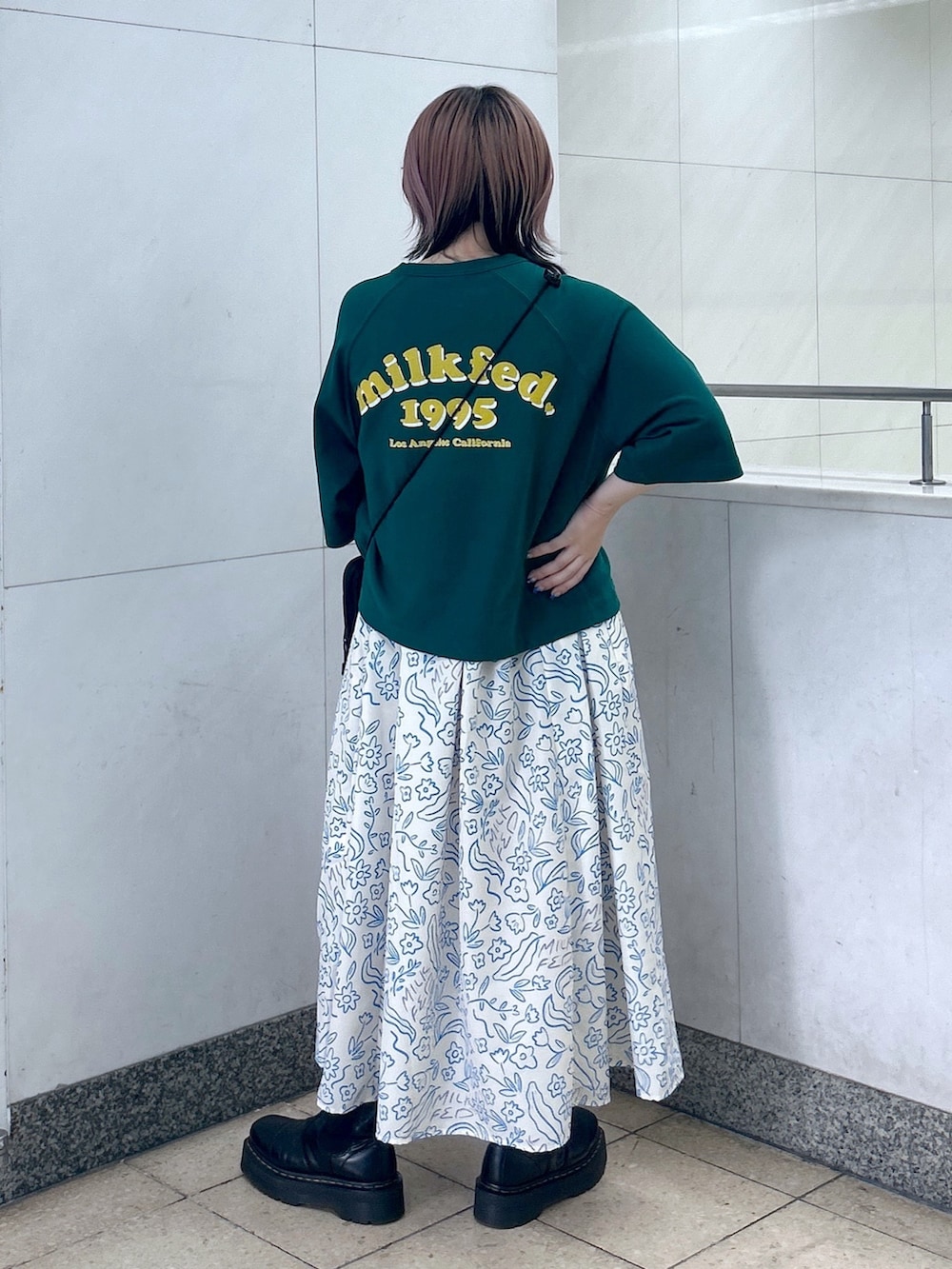 ホワイト系のワンピース、ブラック系のブーツ、グリーン系のショルダーバッグを着用したレディースの夏コーディネートの4枚目の写真