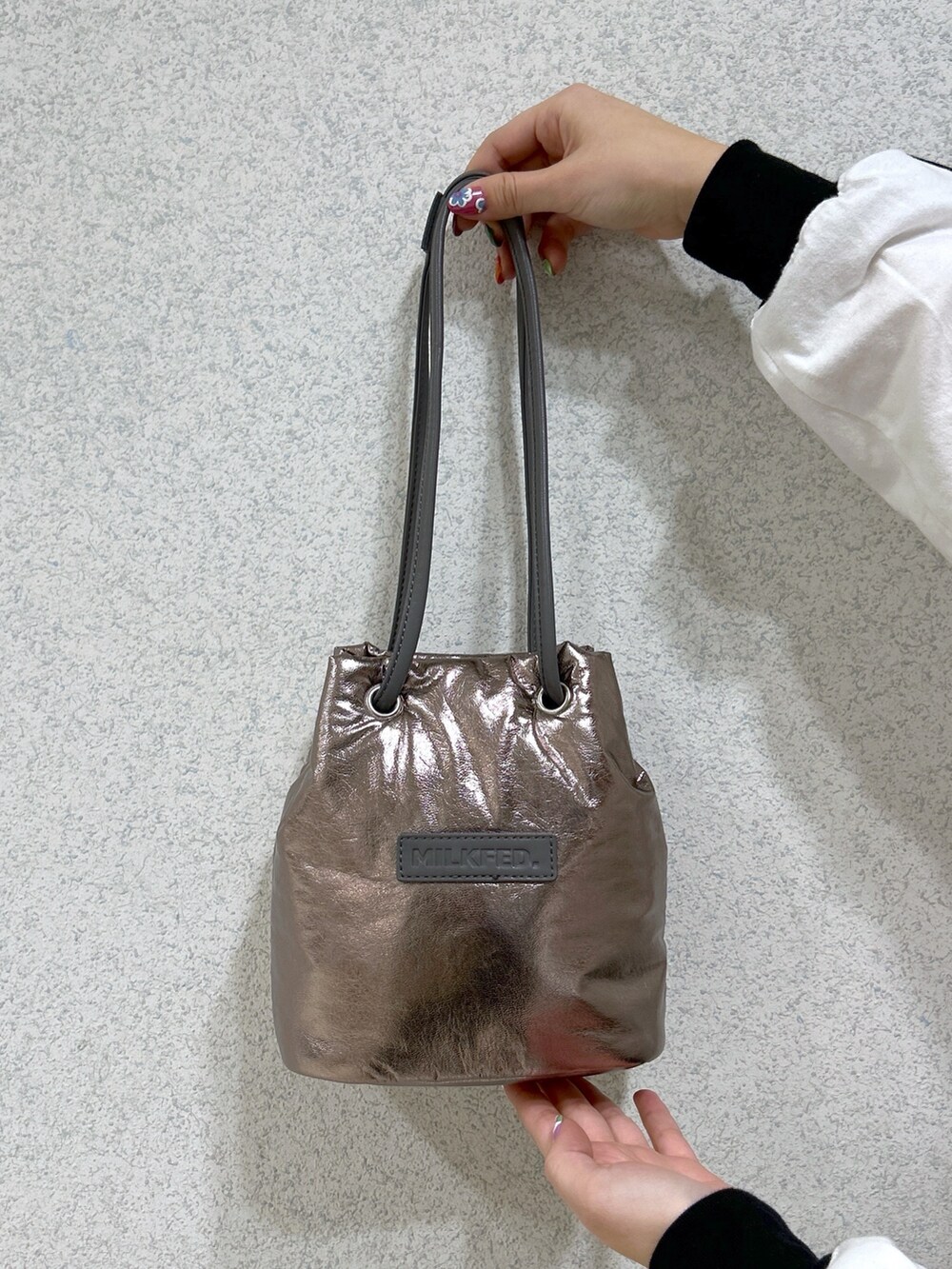 ホワイト系のTシャツ/カットソー、ブラック系のデニムパンツ、シルバー系のショルダーバッグを着用したレディースの冬コーディネートの7枚目の写真